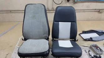 Two chairs side by side, one with a gray fabric seat and backrest, the other with a black seat and backrest with a light blue and beige patch, in an indoor setting.