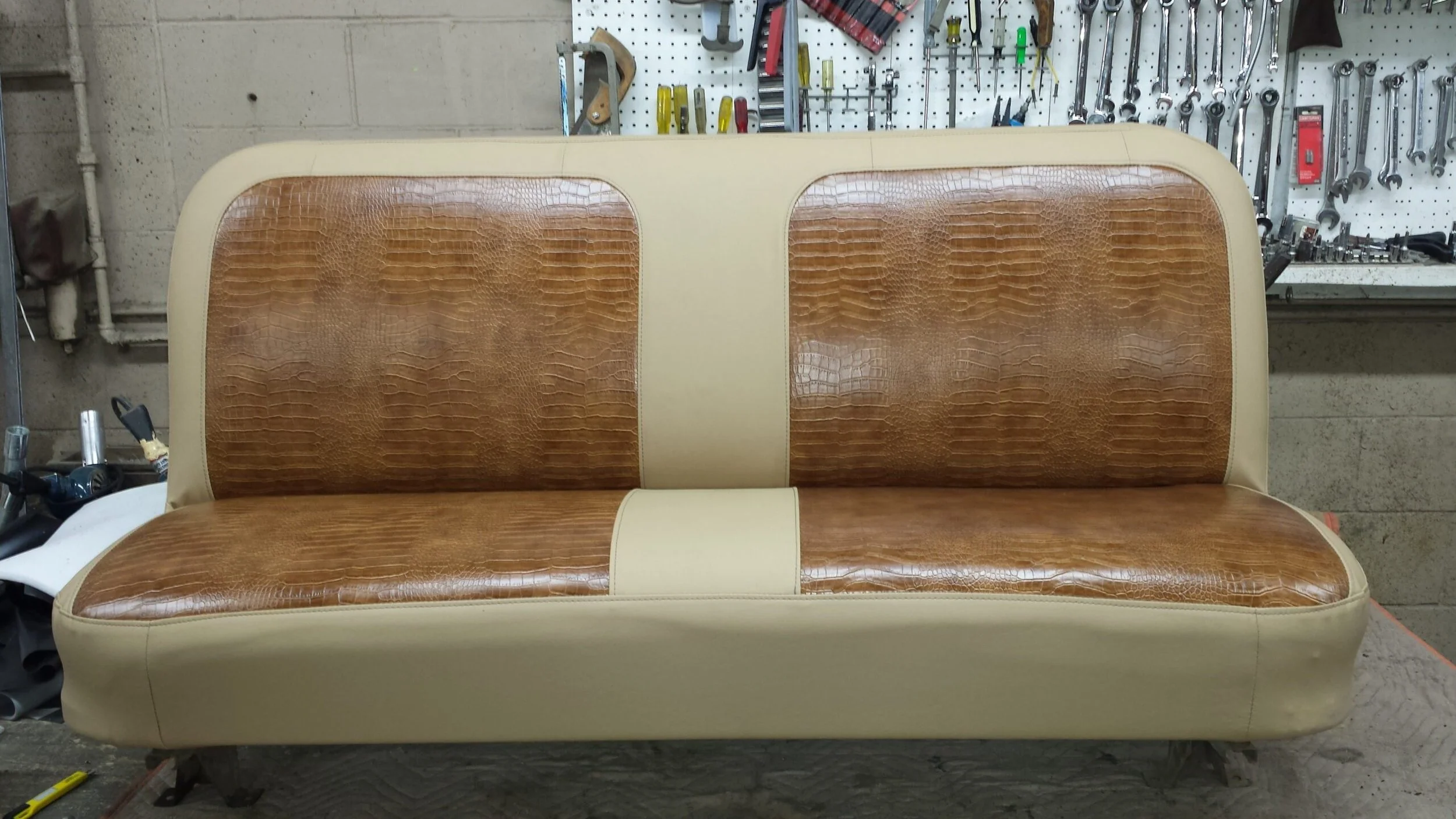 A tan bench with crocodile patterned inserts