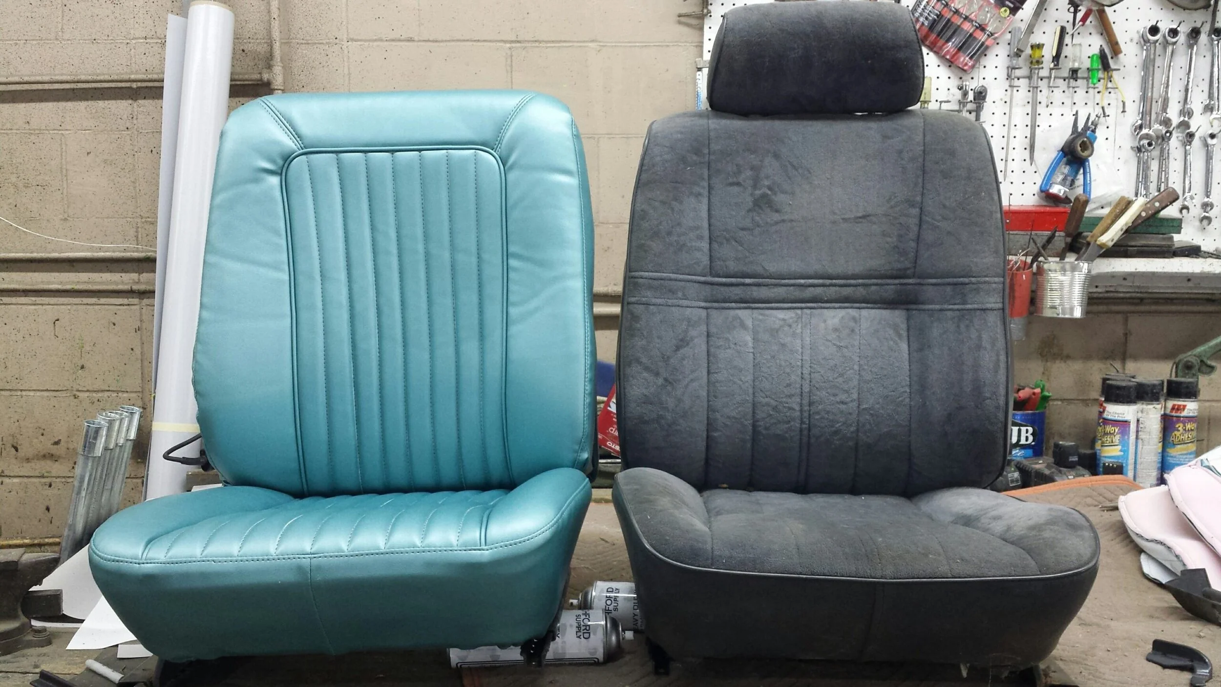 Two automotive seats, one turquoise "After" and one black "before", placed side by side in a workshop. 