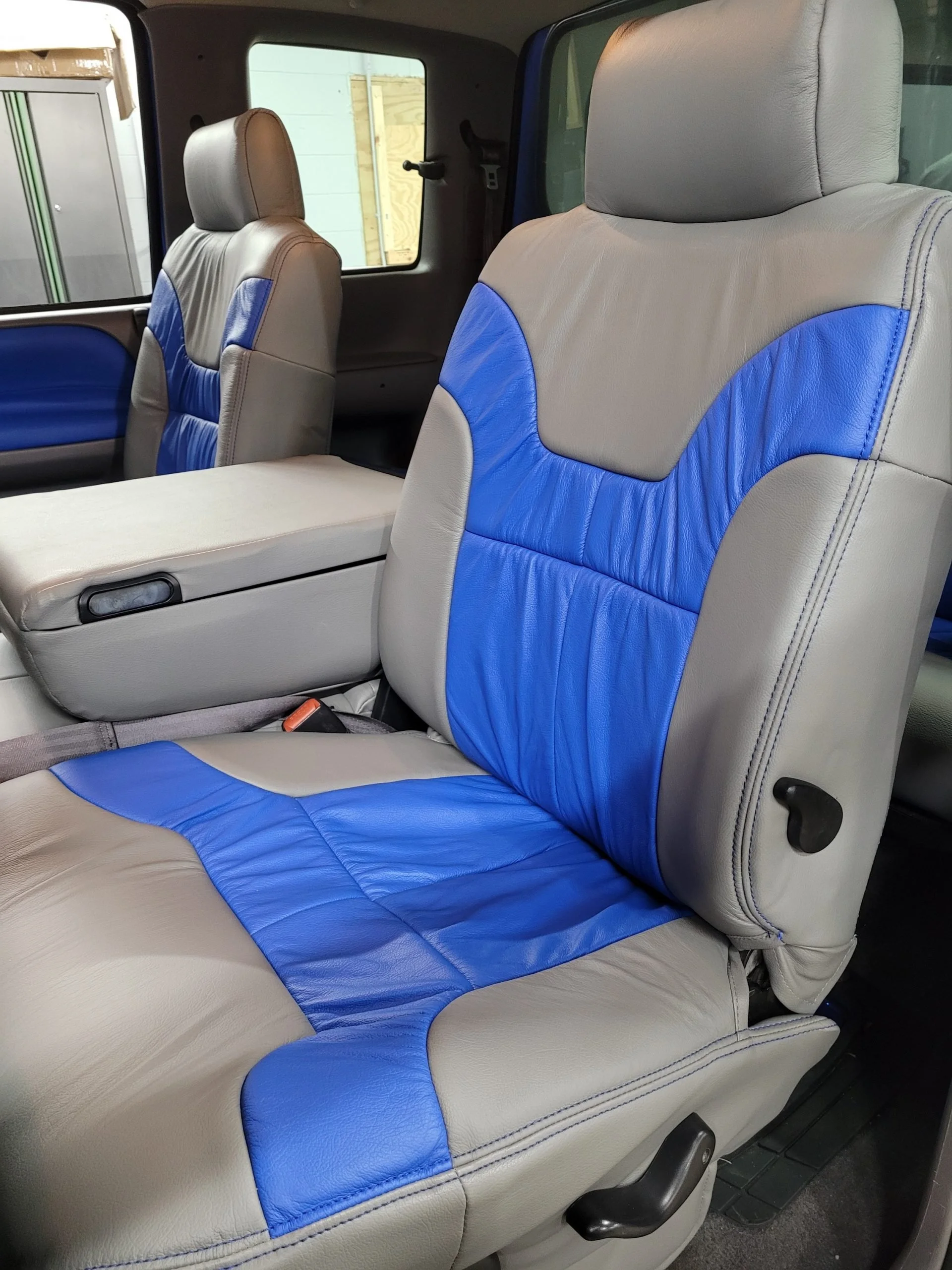 The interior of a vehicle showing Katzkin Leather Kit in grey with blue inserts