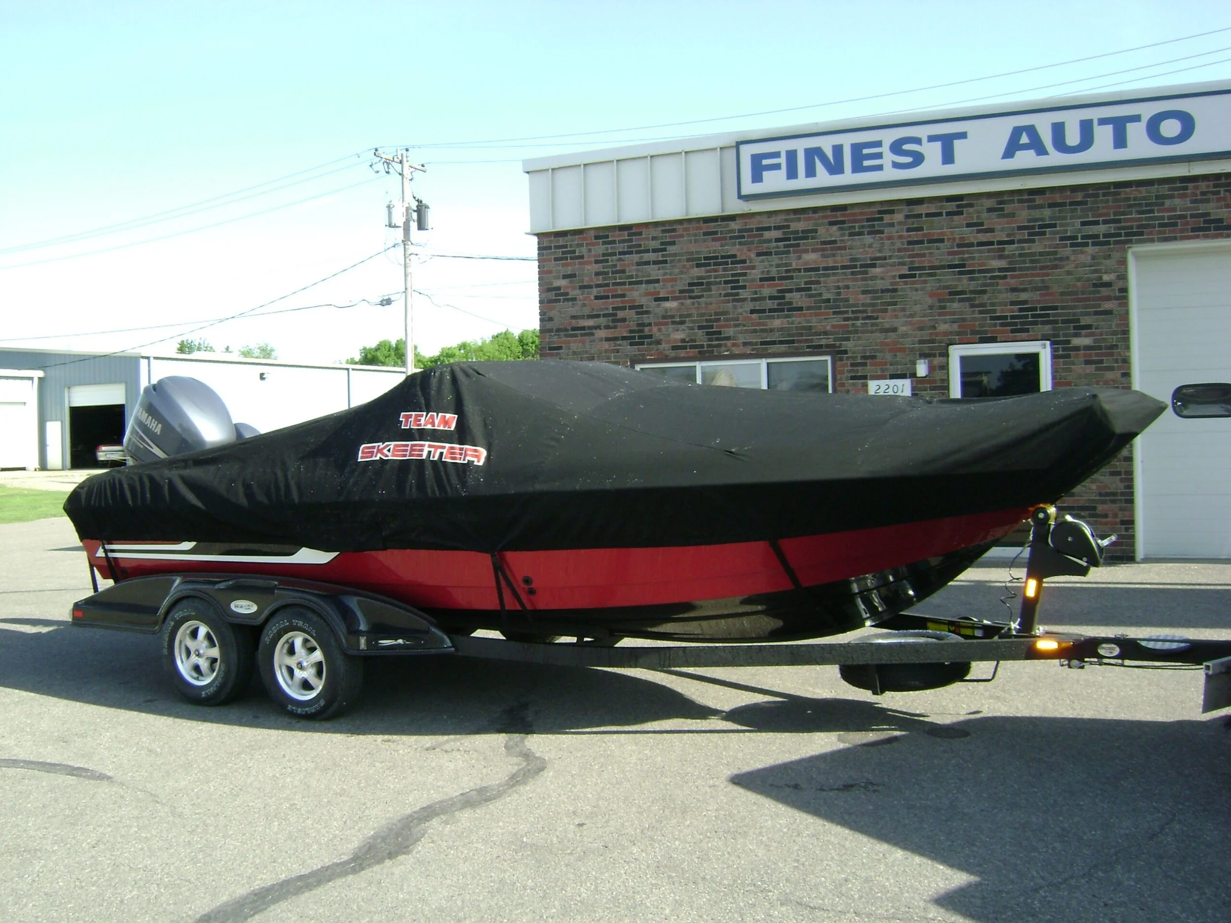 A boat covered with a black custom cover labeled 'Team Skeeter' 