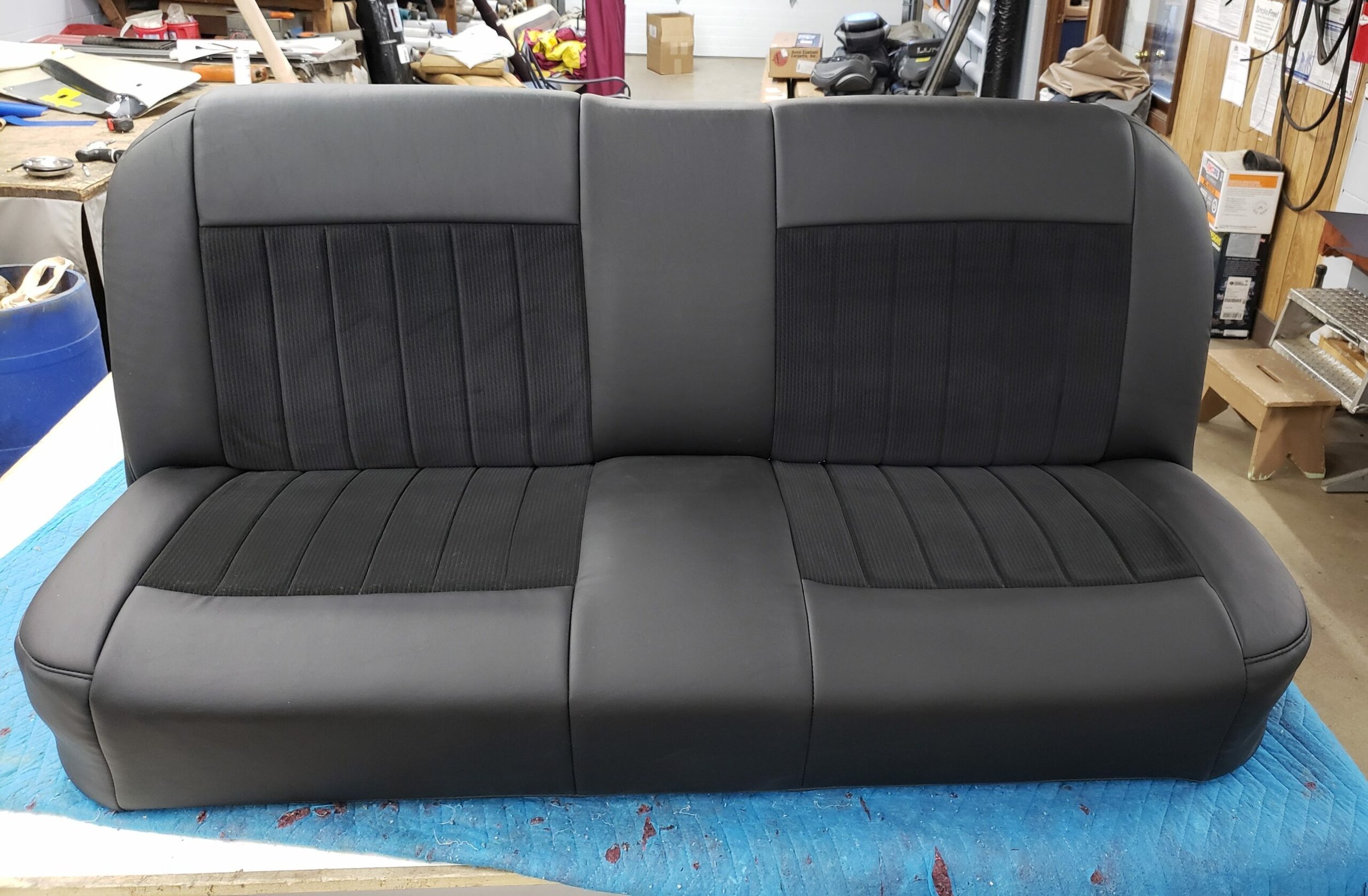 A black vinyl bench seat with pleated black cloth inserts