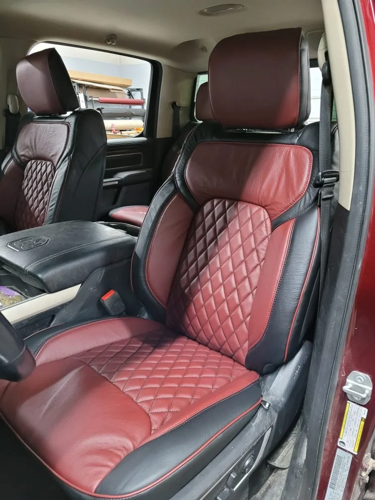 Inside a vehicle showing a front passenger seat with red and black diamond-stitched leather upholstery. Katzkin Leather Kit.