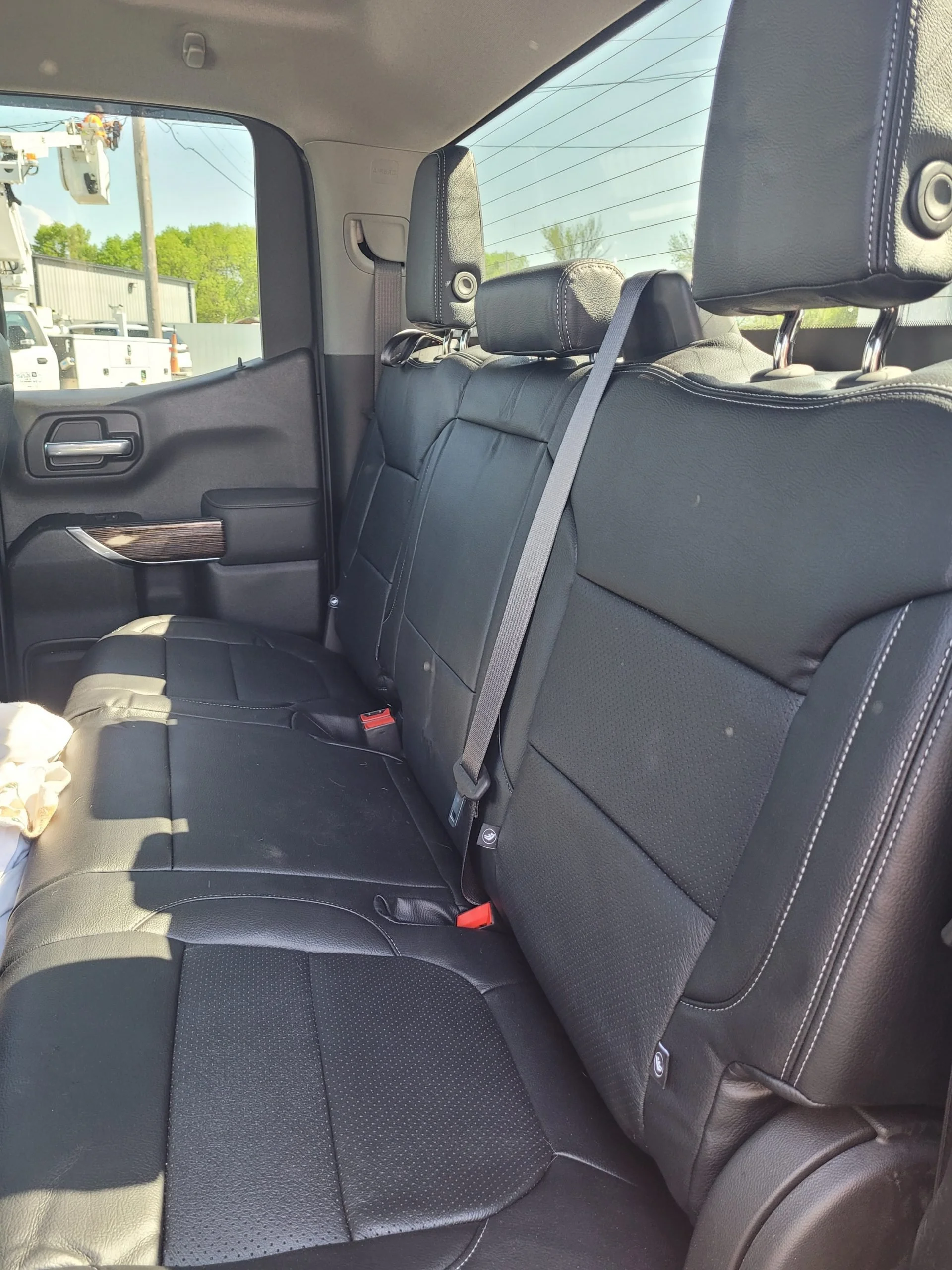 The back seat of a black leather car interior, with two headrests, Katzkin Leather Kit.
