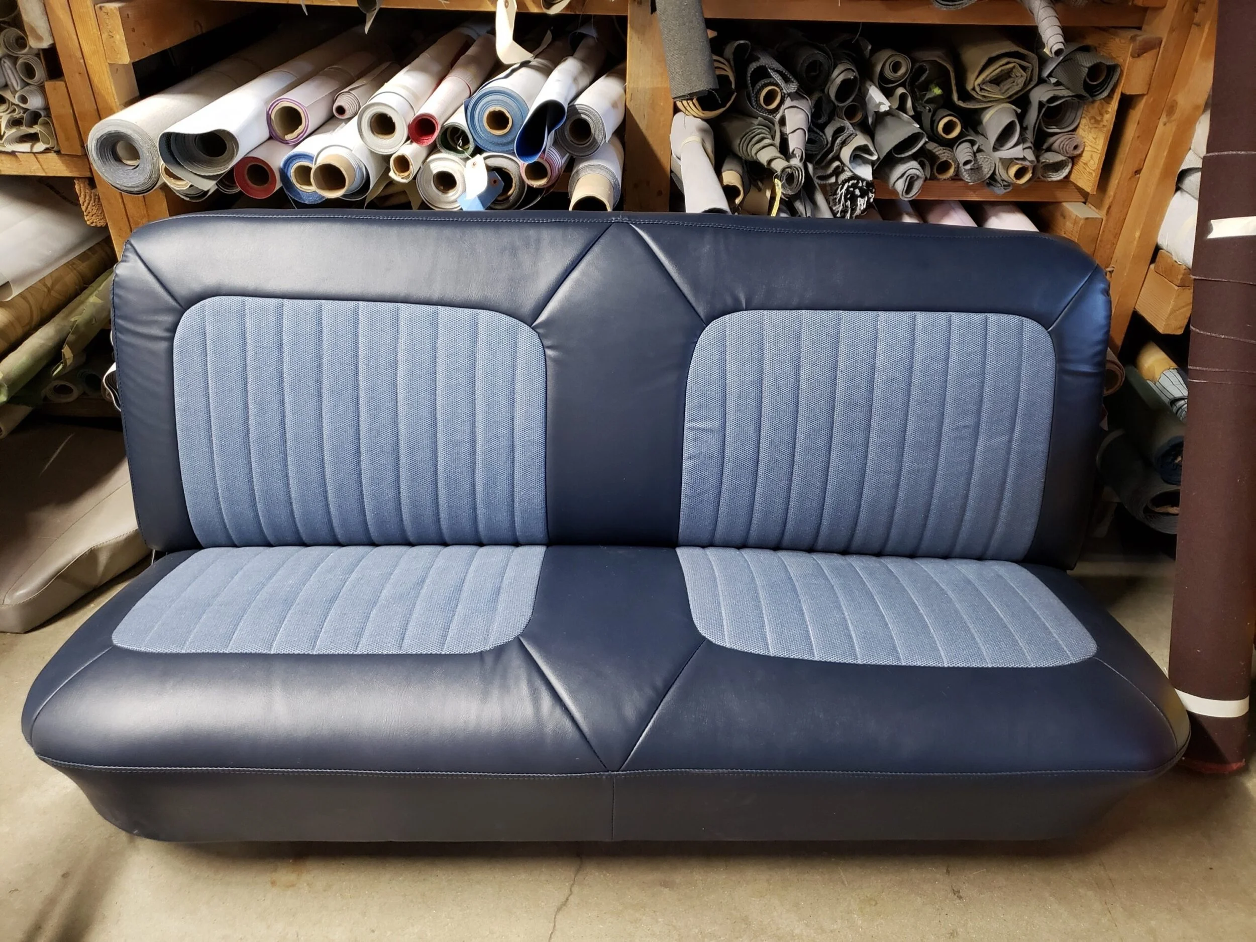 A navy blue bench seat with cloth vertical pleats