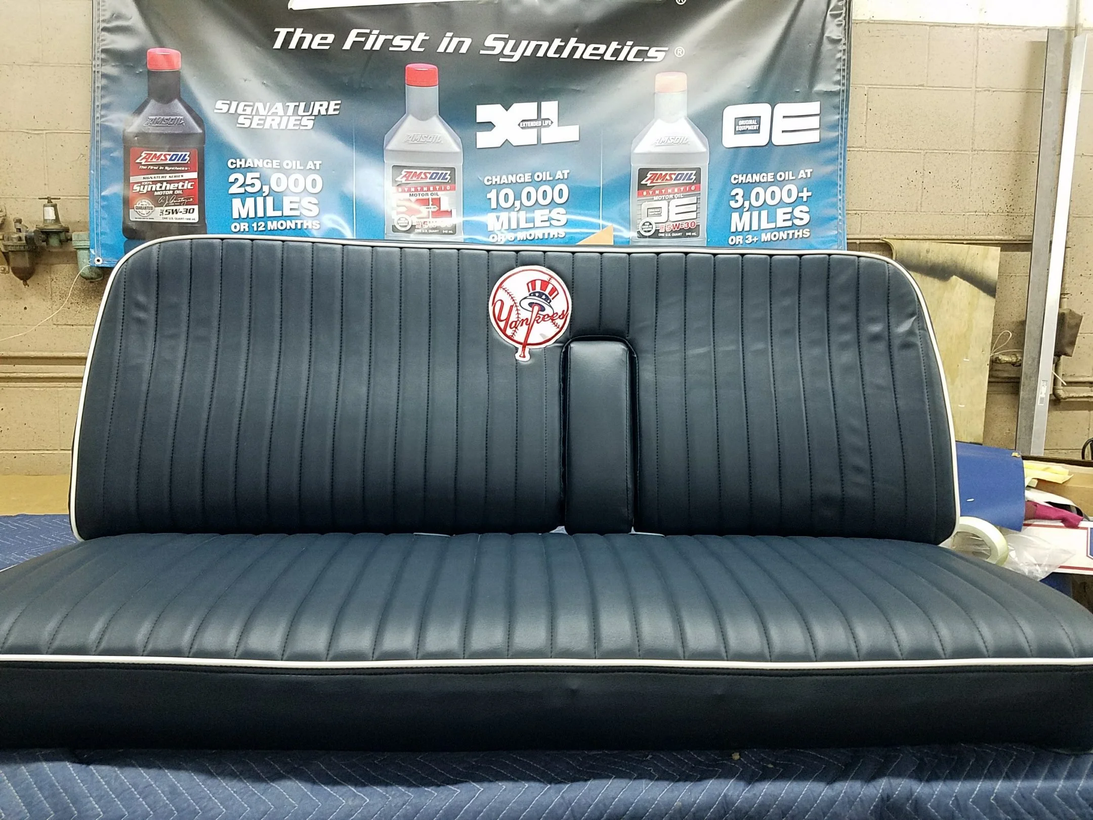 A black bench seat with vertical pleats and a Yankees logo