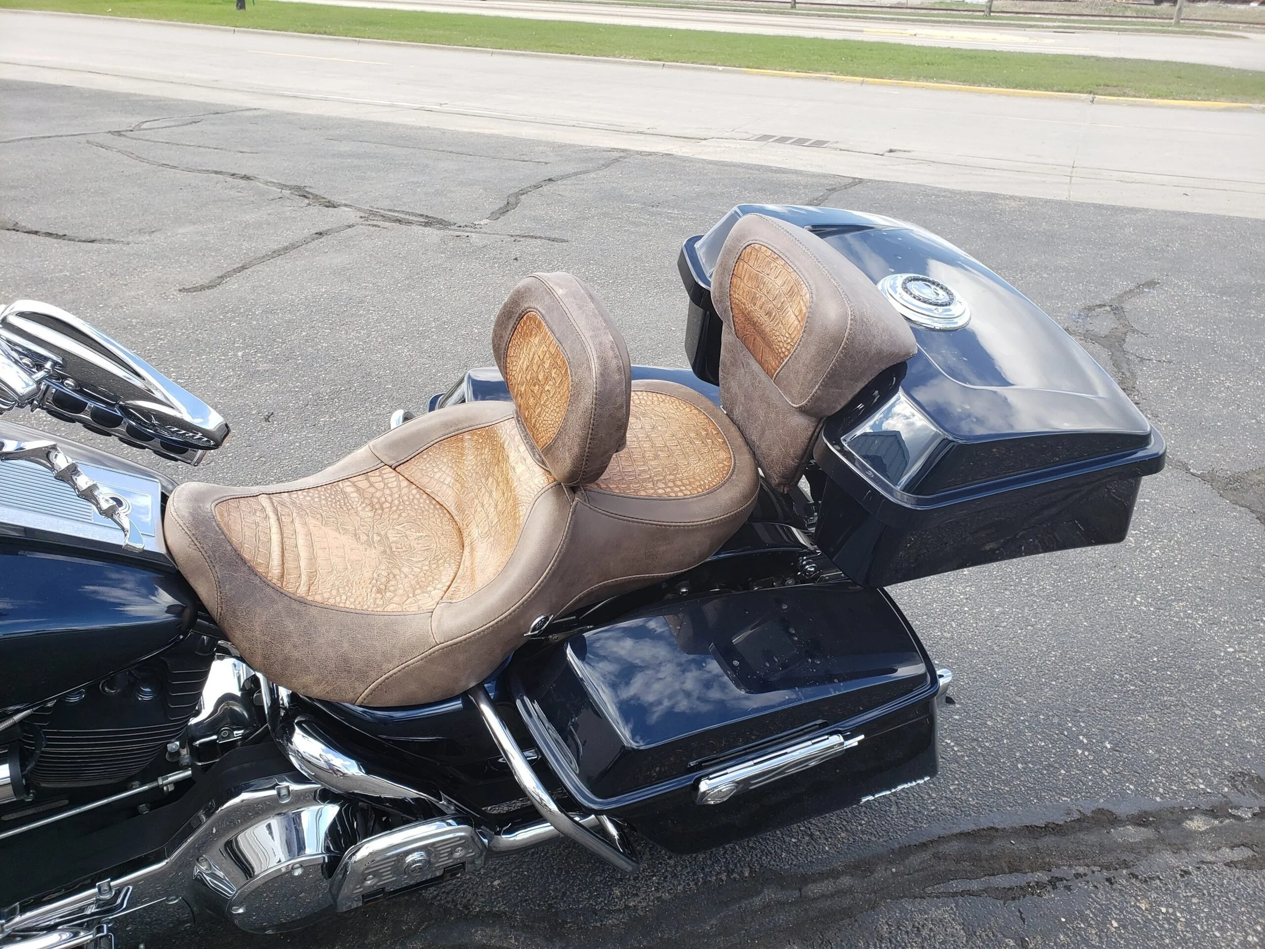 A black motorcycle with brown leather seats with crocodile textured leather.