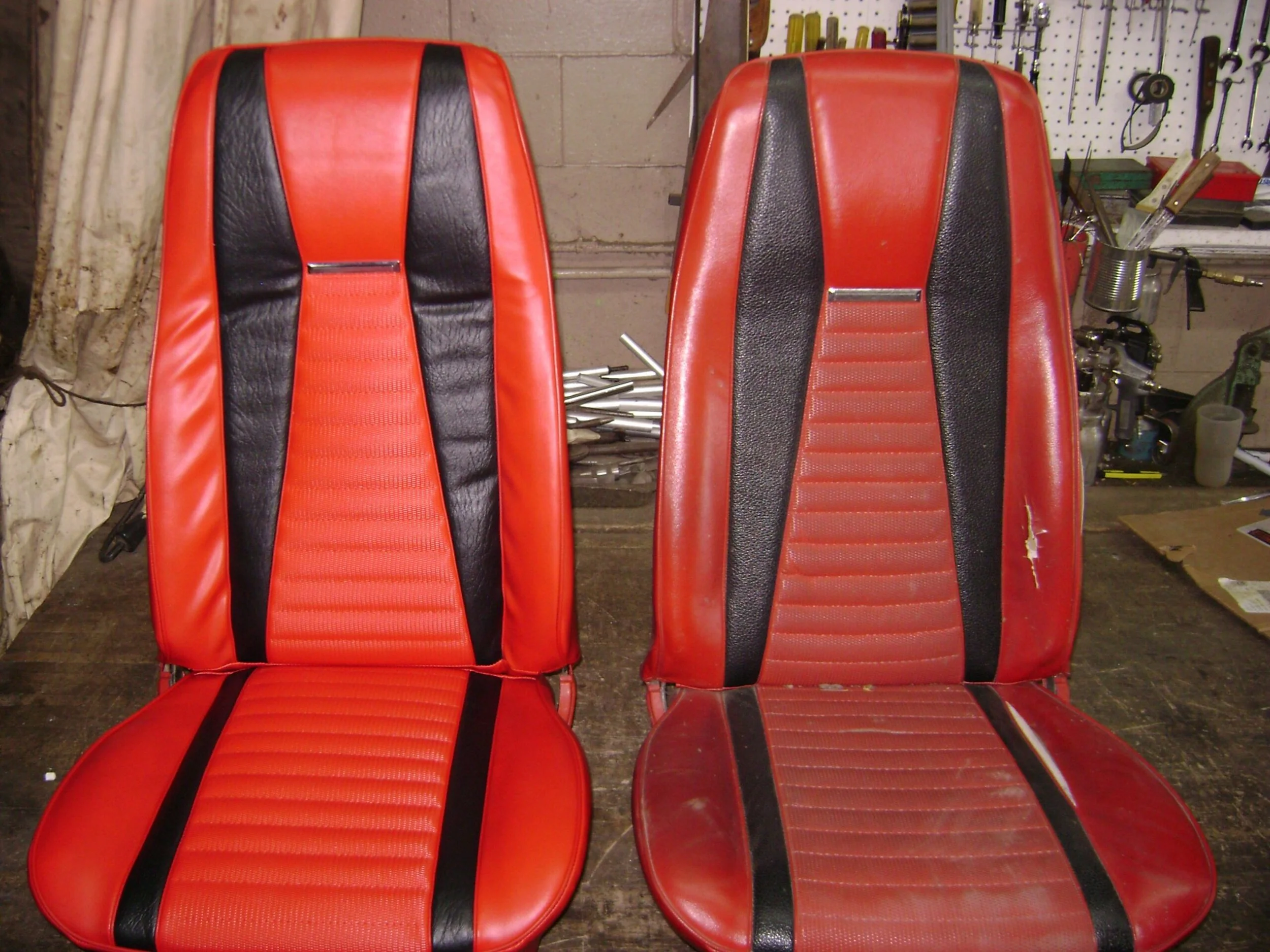 Two vintage red and black racing seats, left is the "after" seat.