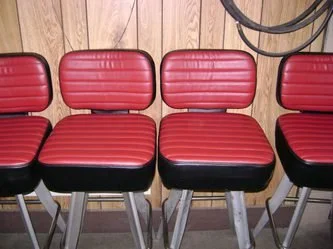Four red and black retro-style chairs, recovered.