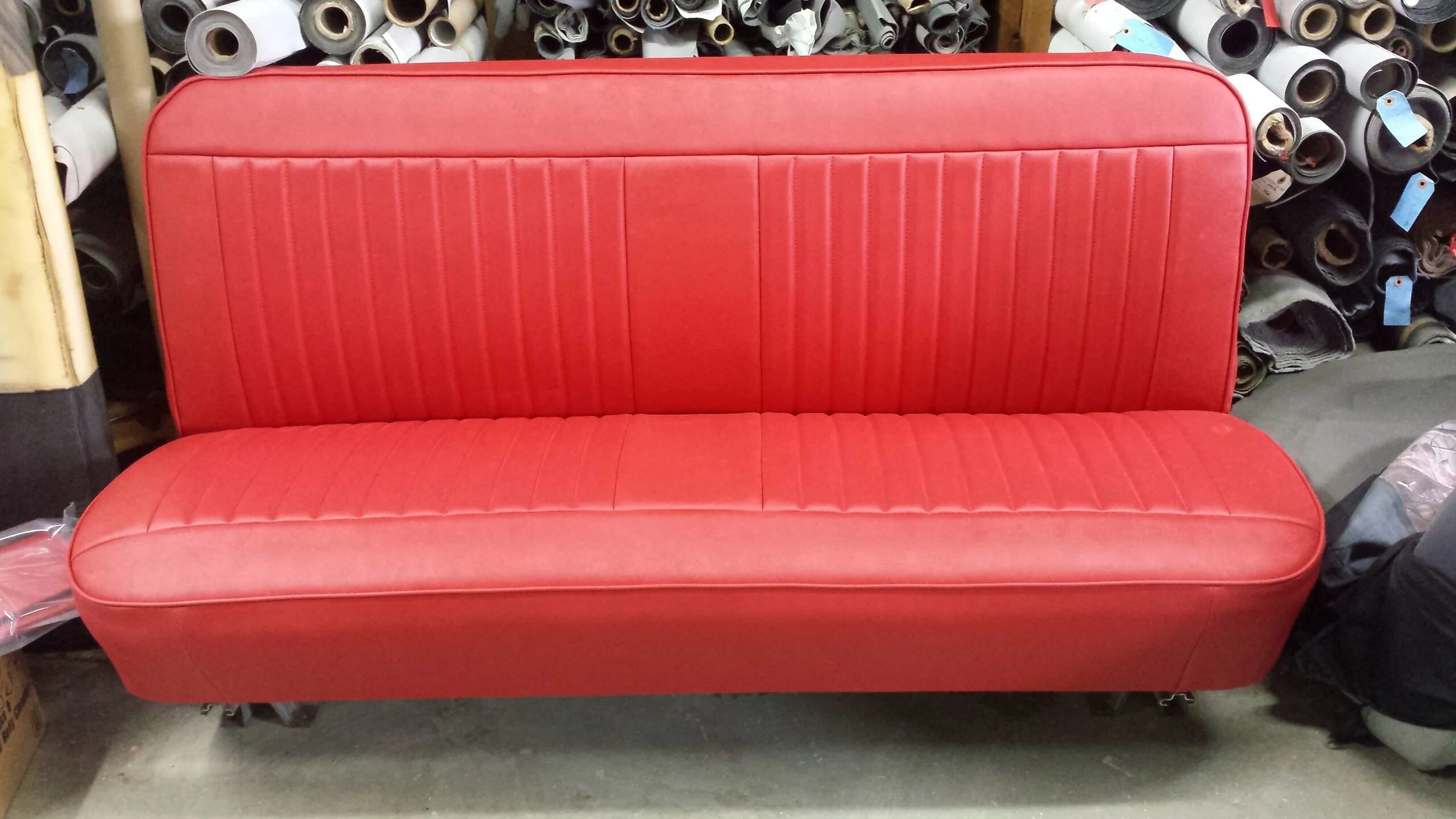 A red vintage truck vinyl bench seat with vertical pleats
