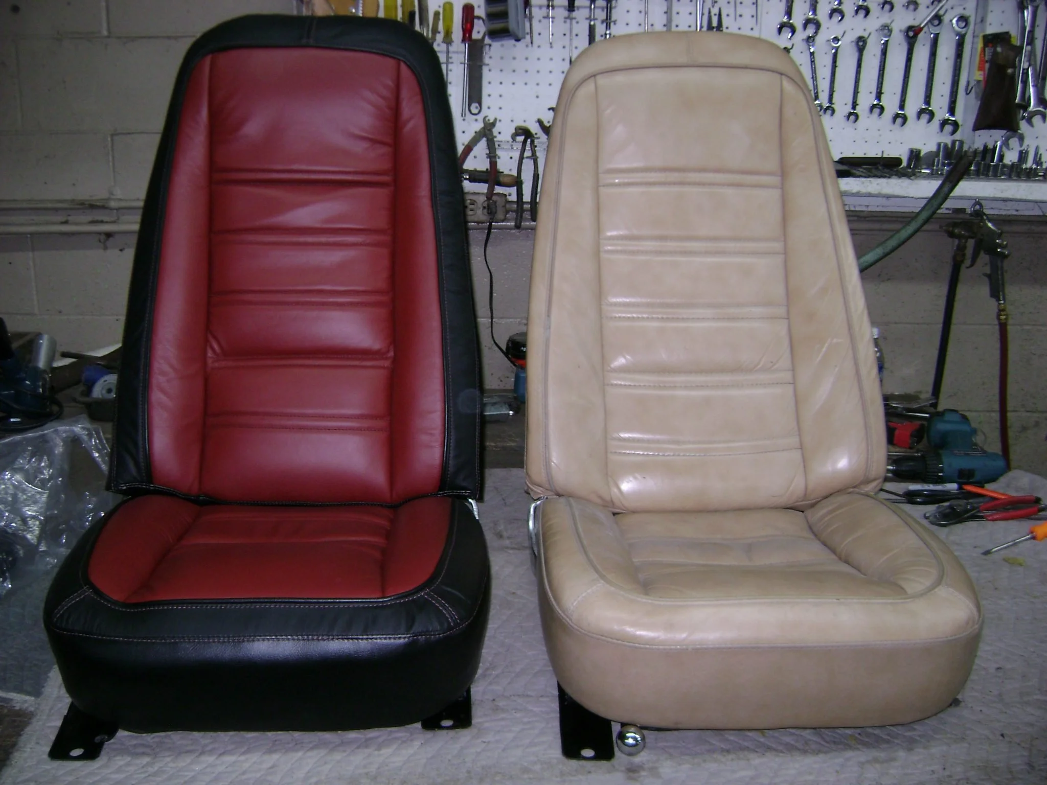 Two car seats, one red and black, and one beige, are placed side by side.