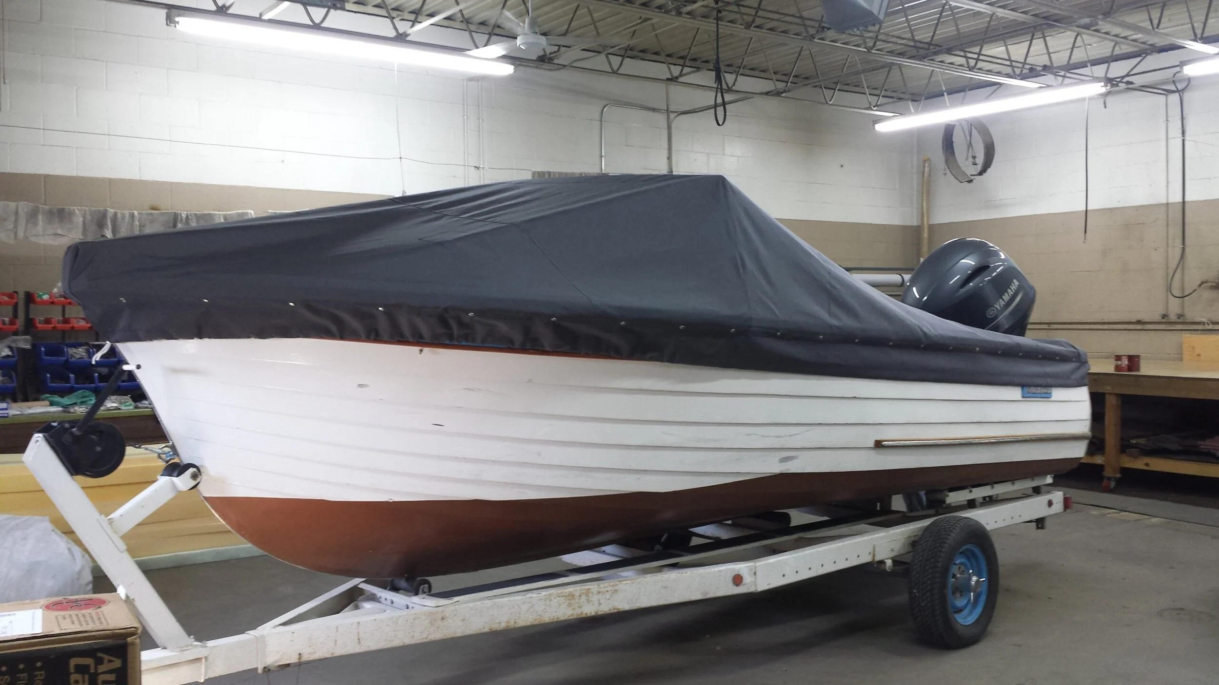 A vintage wood boat with a black custom cover 