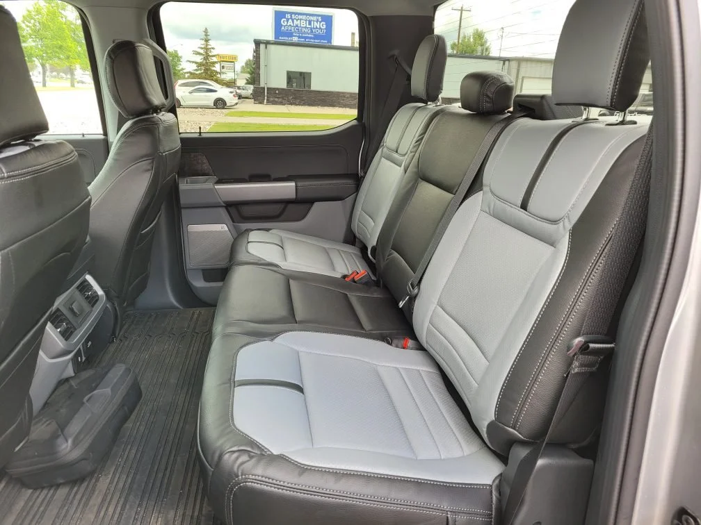 The interior of a vehicle showing the second row of seats with black and gray (Lapis) upholstery, Katzkin Leather Kit.