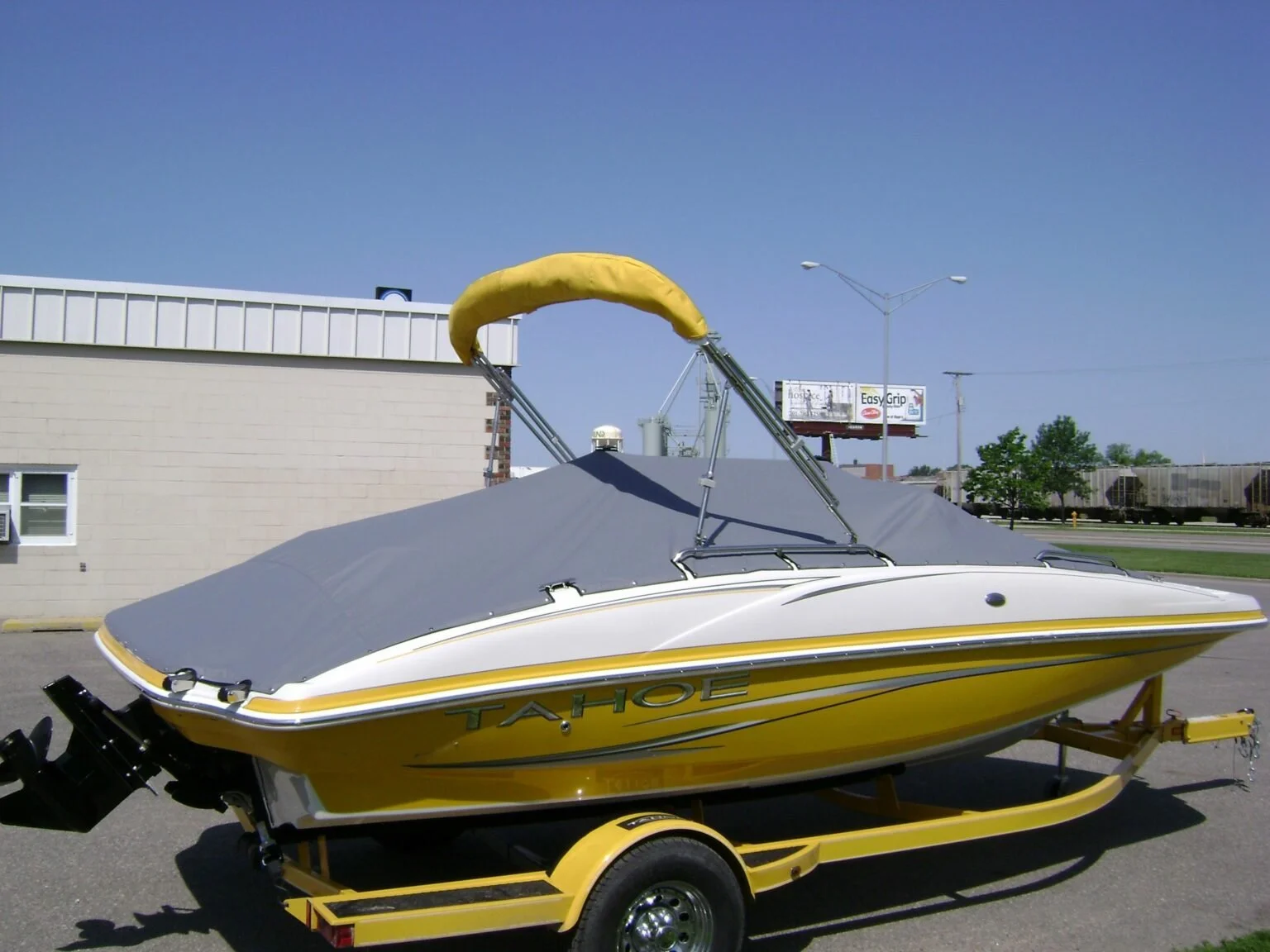 Yellow and white speedboat with a gray Snap-on boat cover