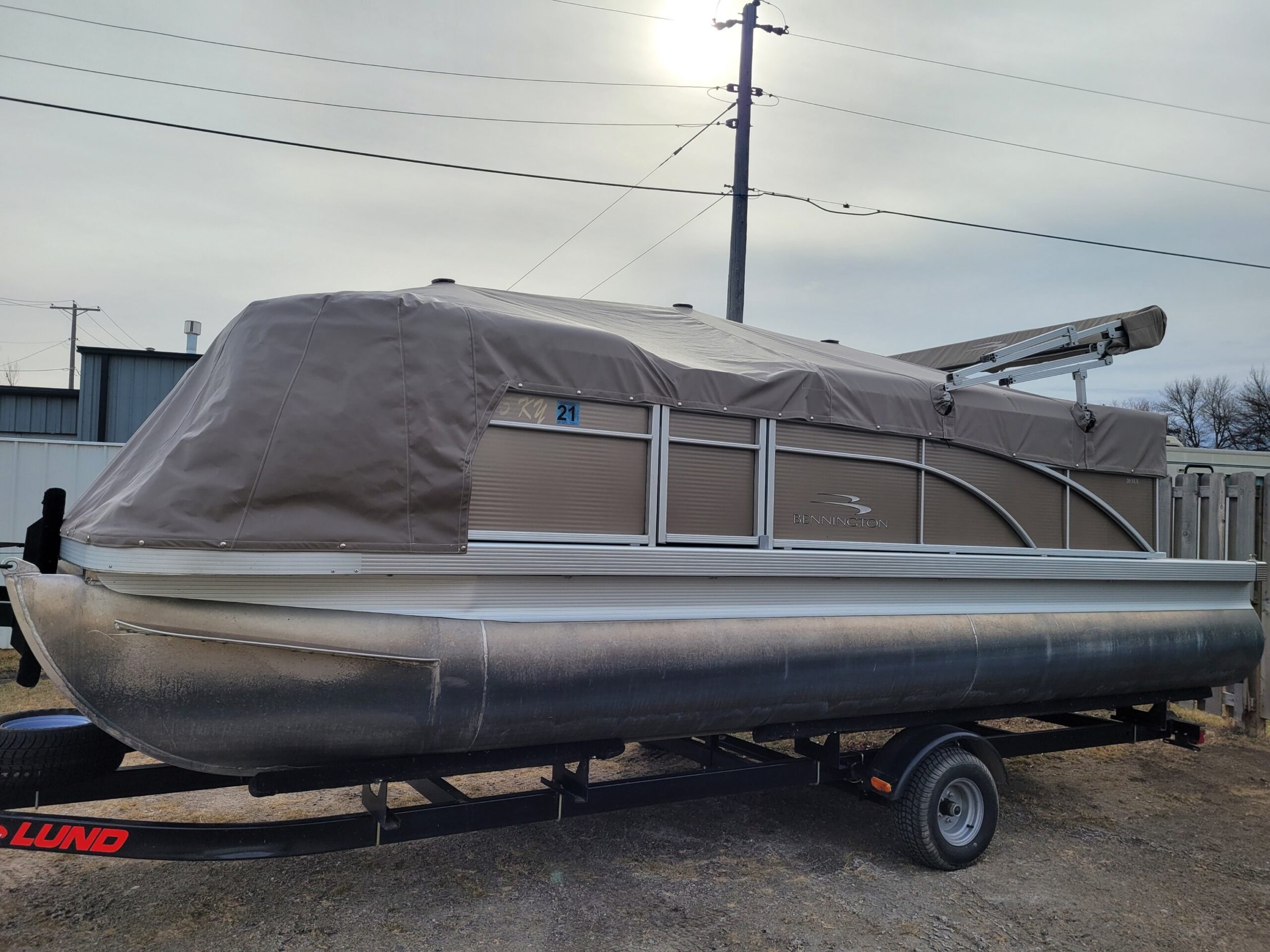 A pontoon with a beige custom cover 