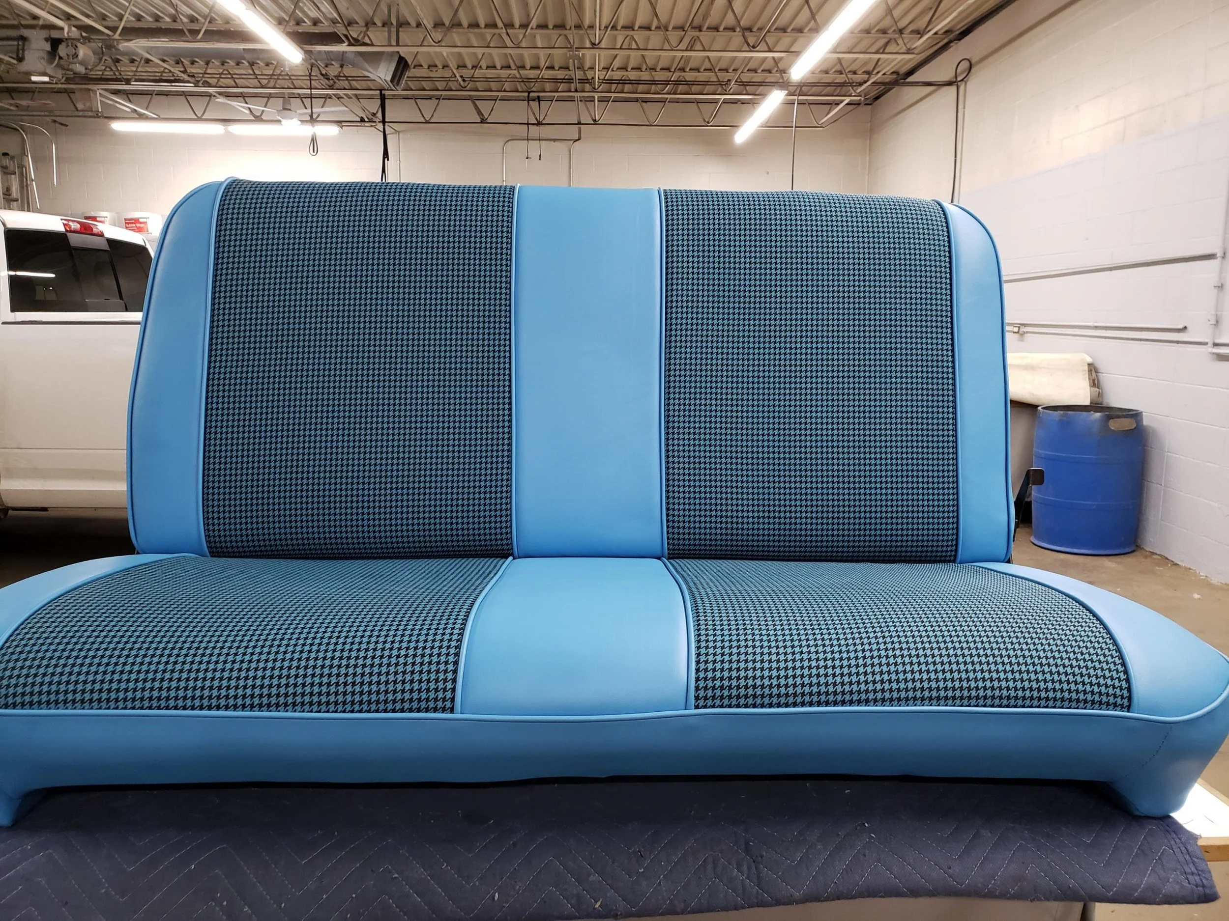 A light blue bench featuring a houndstooth pattern fabric for inserts