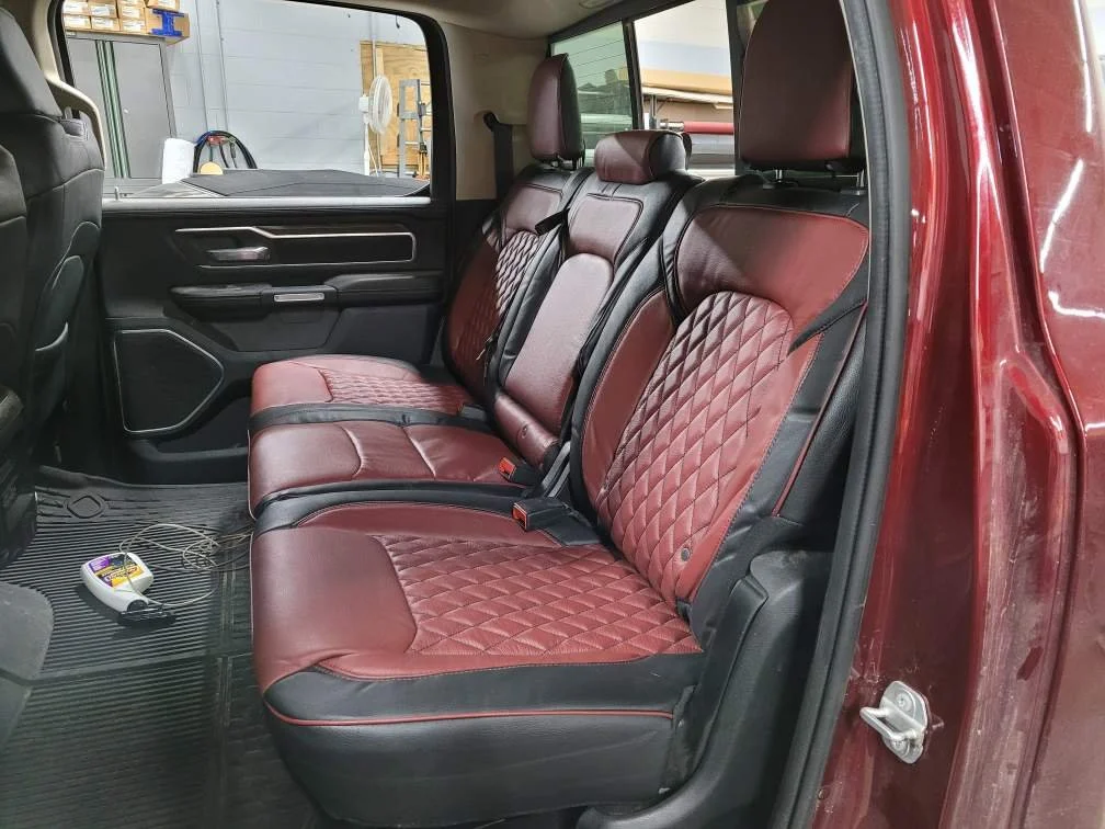 The backseat of a red pickup truck, featuring red and black quilted seat covers, Katzkin Leather Kit.