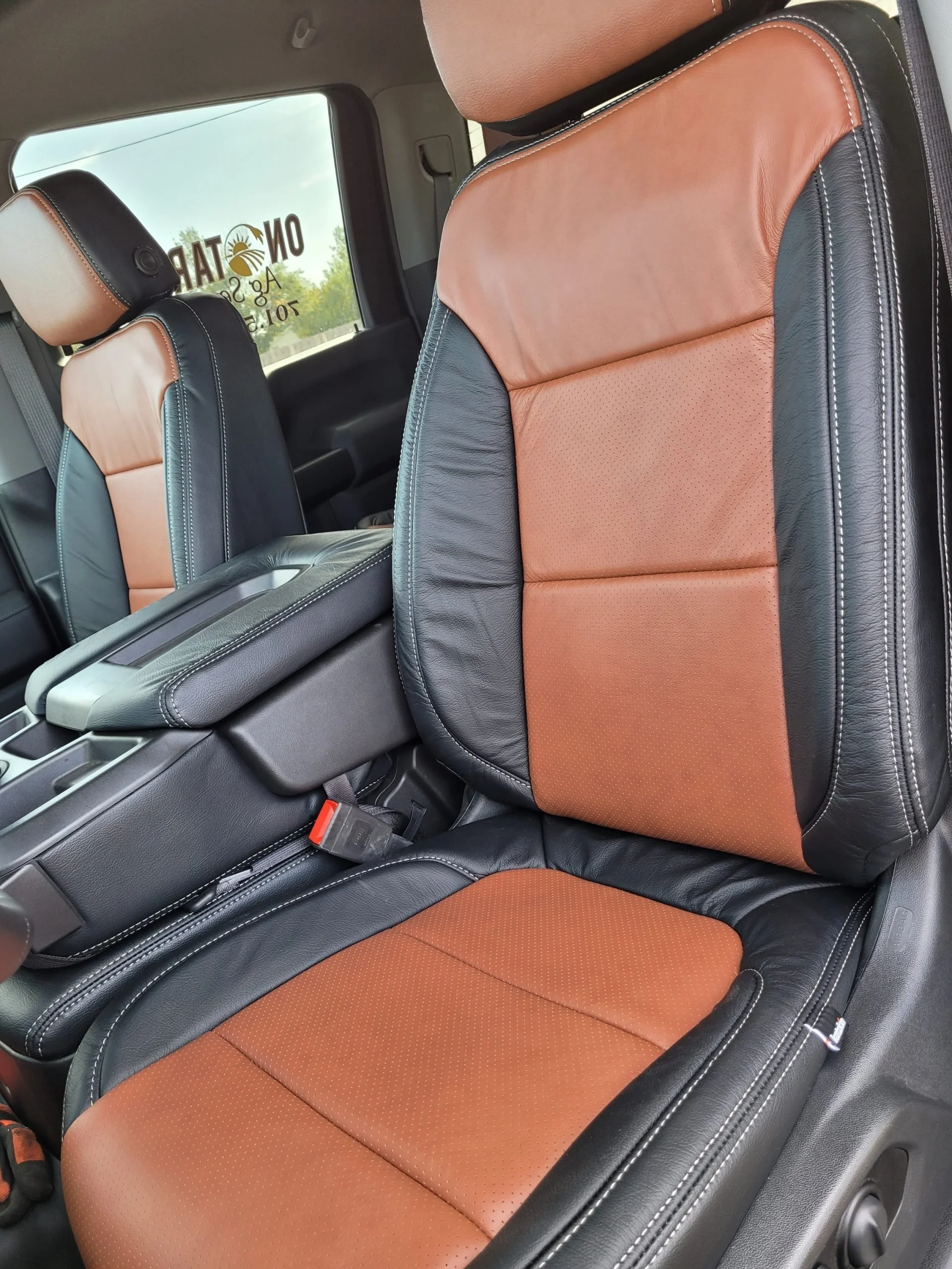 The interior of a vehicle showing black and brown leather seats with Katzkin Leather Kit.