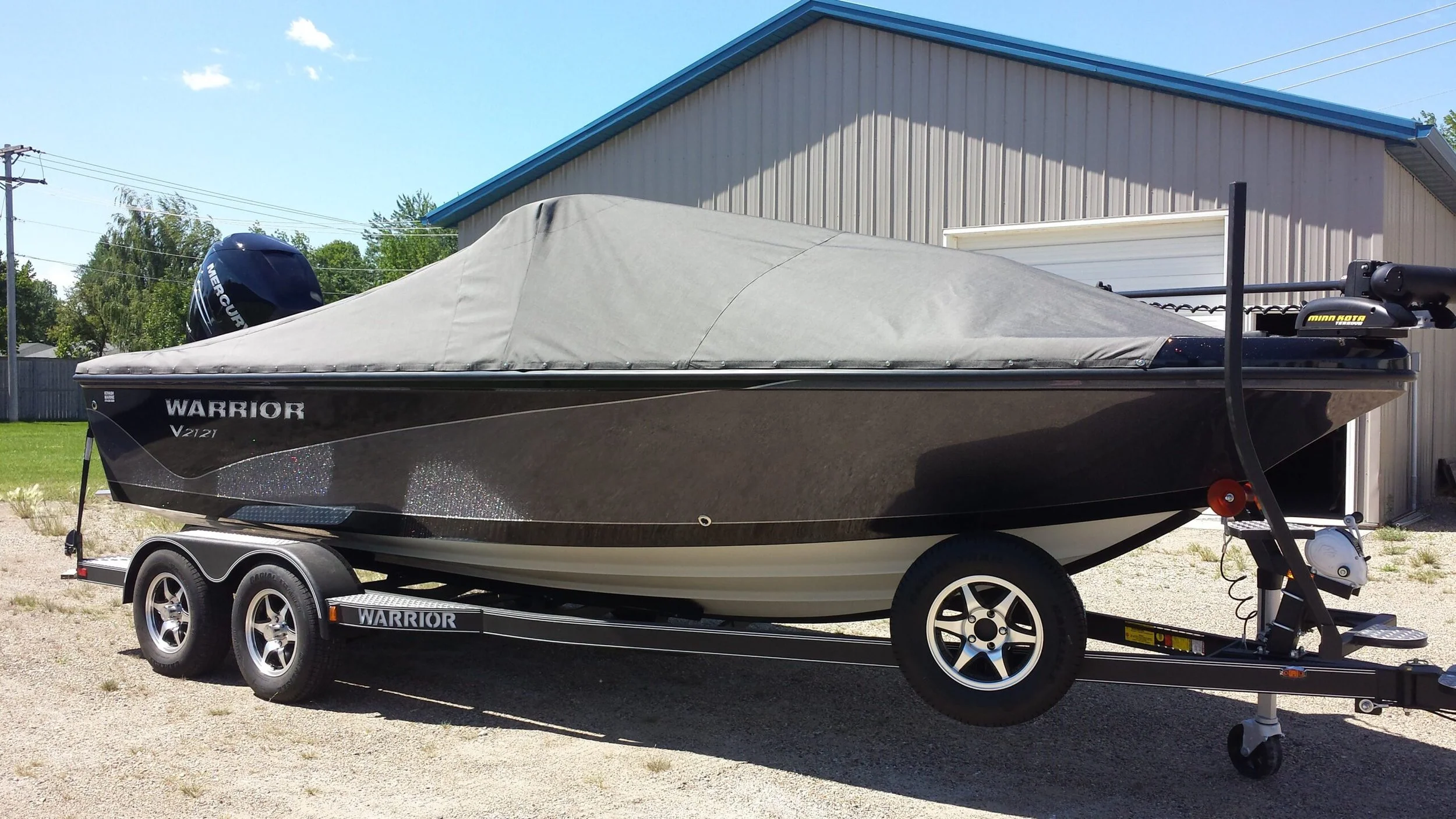 A black Warrior boat with custom charcoal boat cover