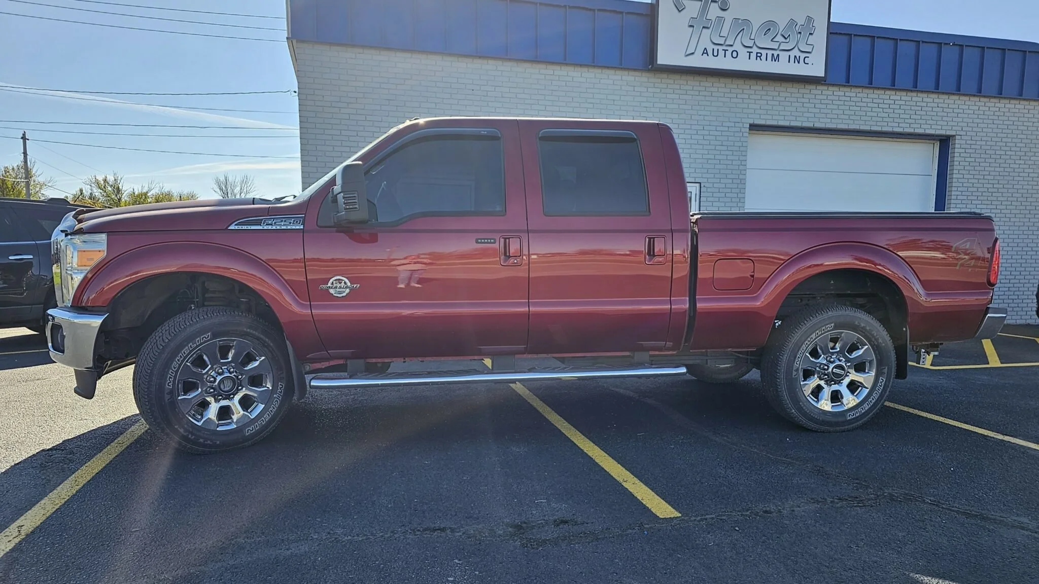 A red Ford F-250 Super Duty pickup truck parked in front of 'Finest Auto Trim Inc.' Owner's vehicle, Darin Sorenson.