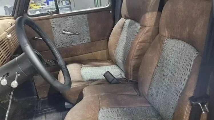 Interior of a vintage vehicle with vintage brown upholstery seats featuring patterned crocodile inserts