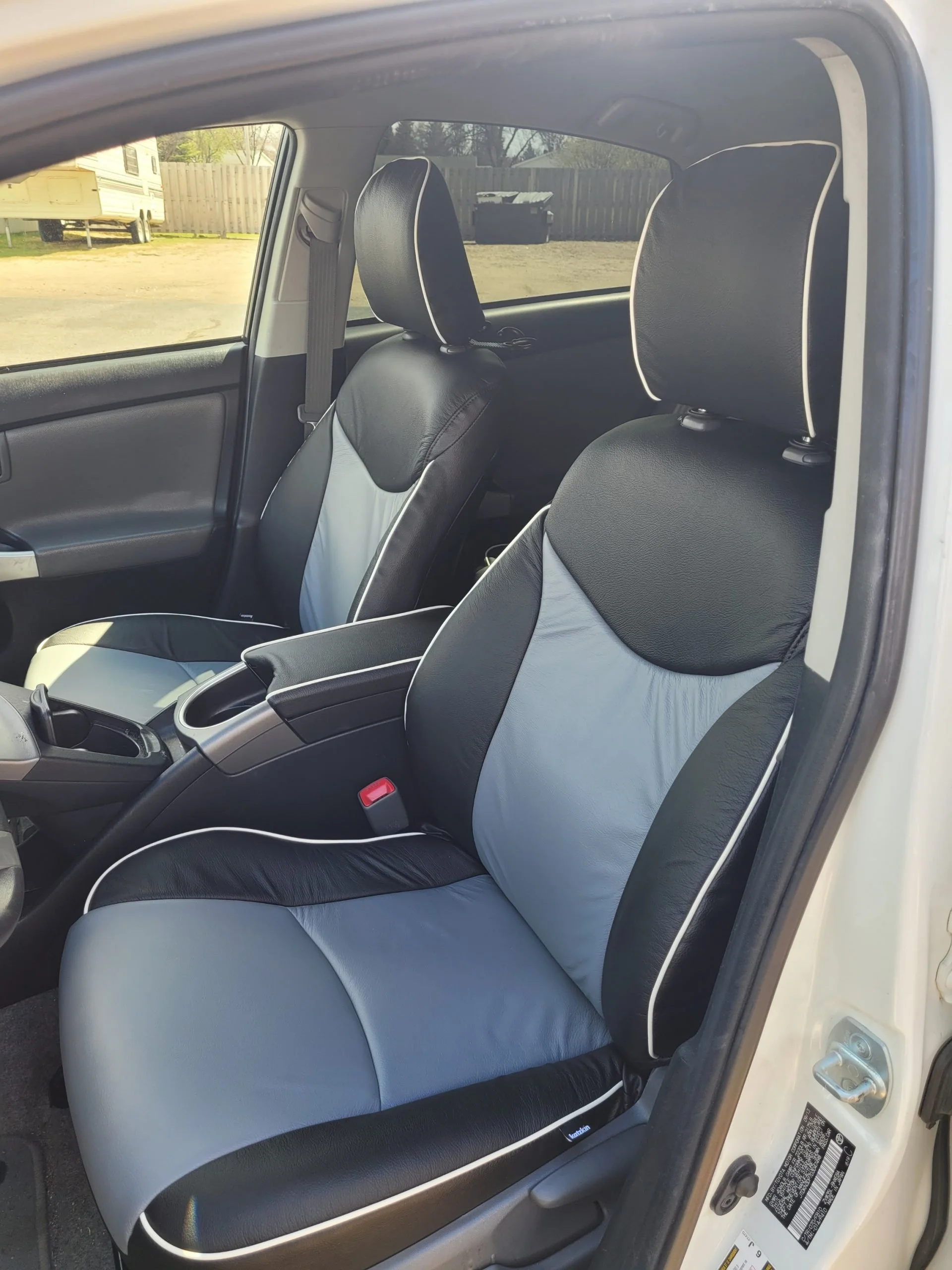 The interior of a car showing the front seats with Katzkin Kit installed. Black with blue inserts.