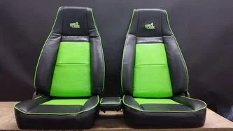 Two Jeep seats with black and green upholstery 