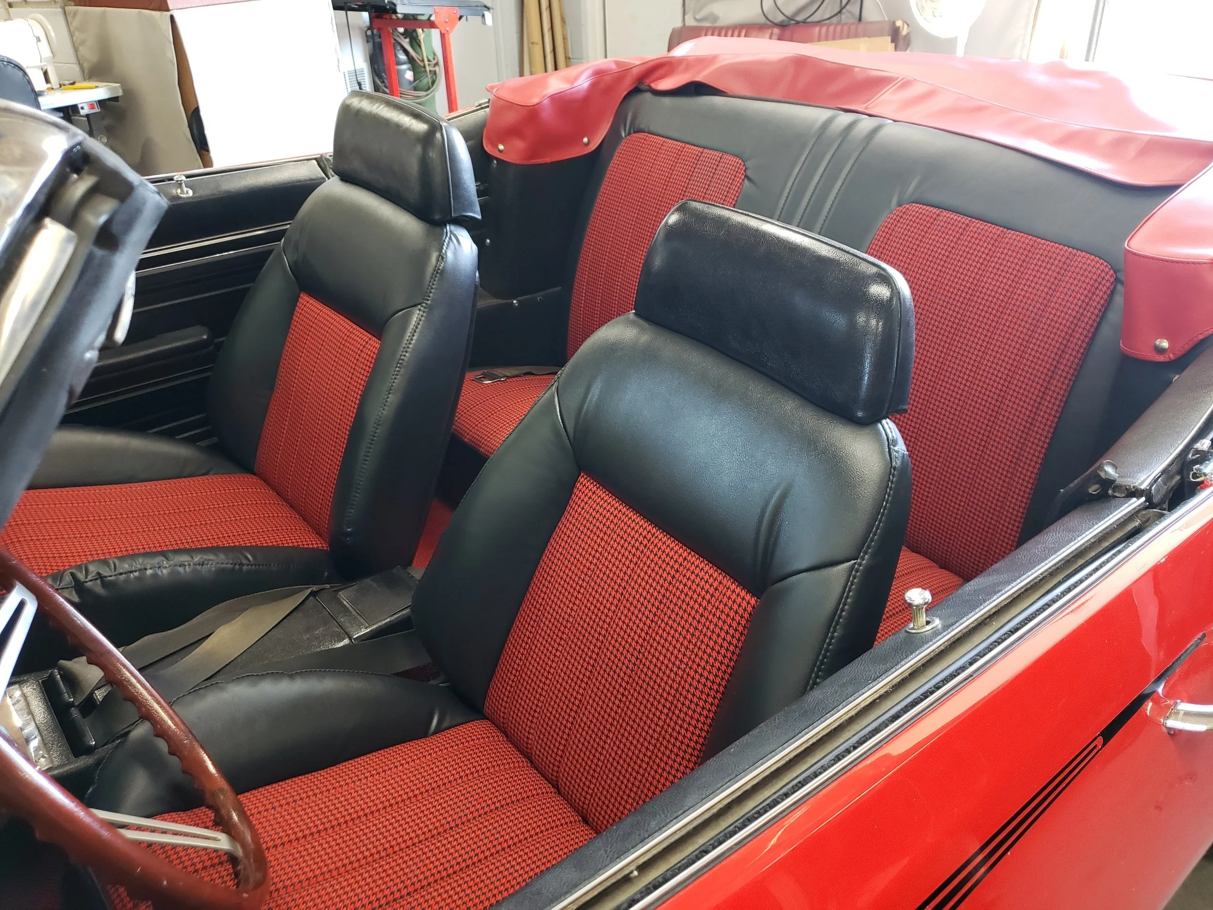 Interior of a Corvette convertible, red car with black and red houndstooth inserts