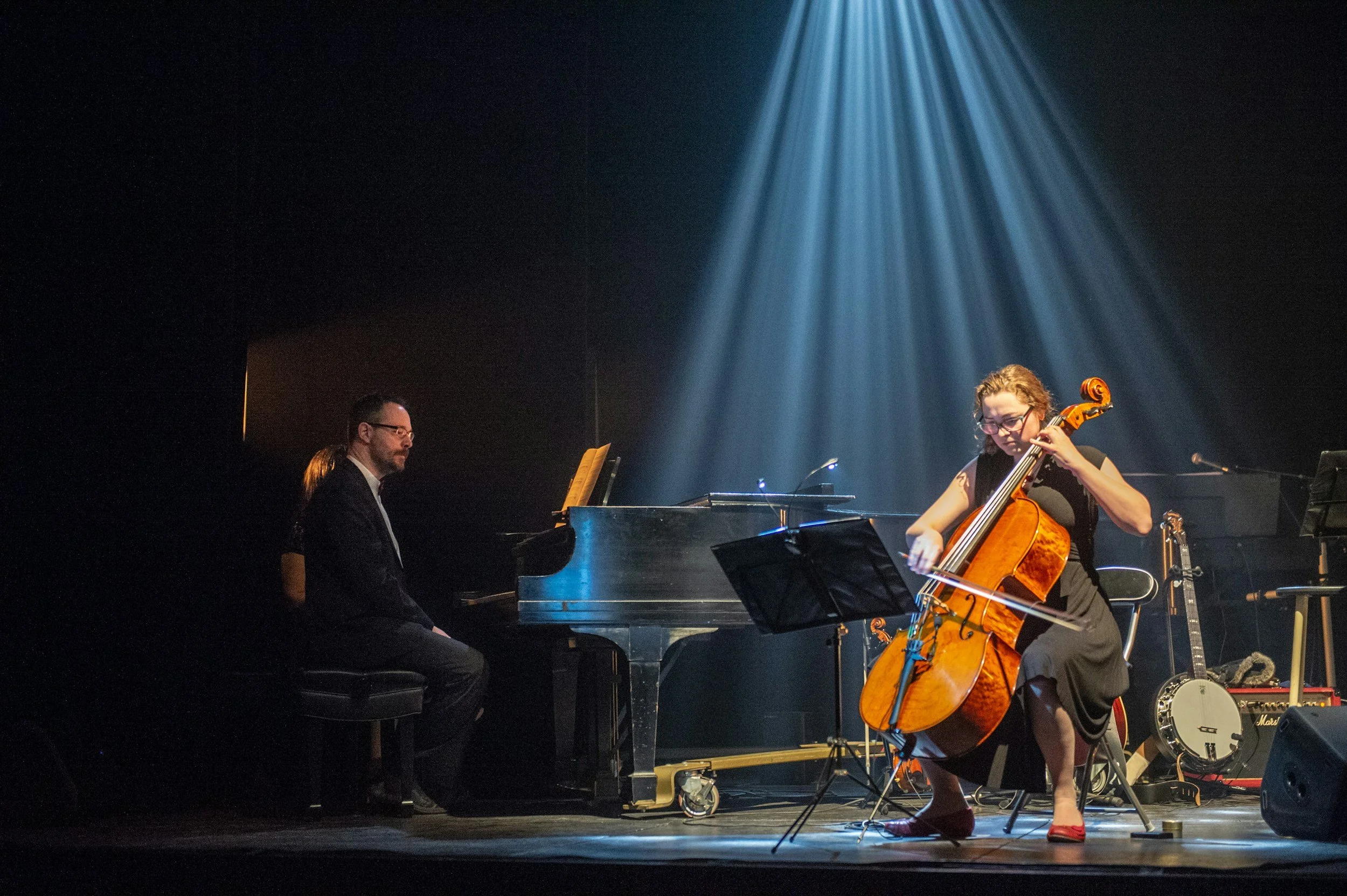 Cellist and pianist performing together onstage.