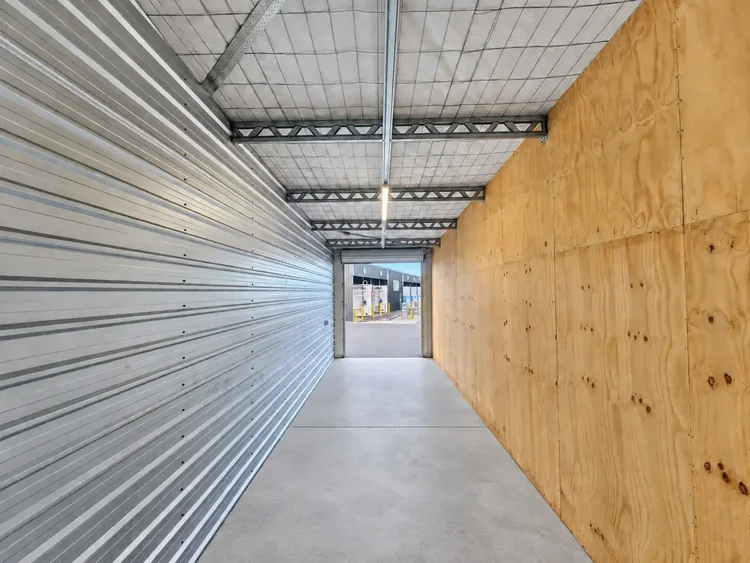 Inside a Ravenswood storage unit with timber wall, concrete floor and high ceiling