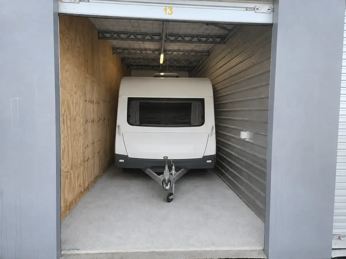 Compact caravan parked inside a secure indoor storage unit at Myt4you Storage Ravenswood