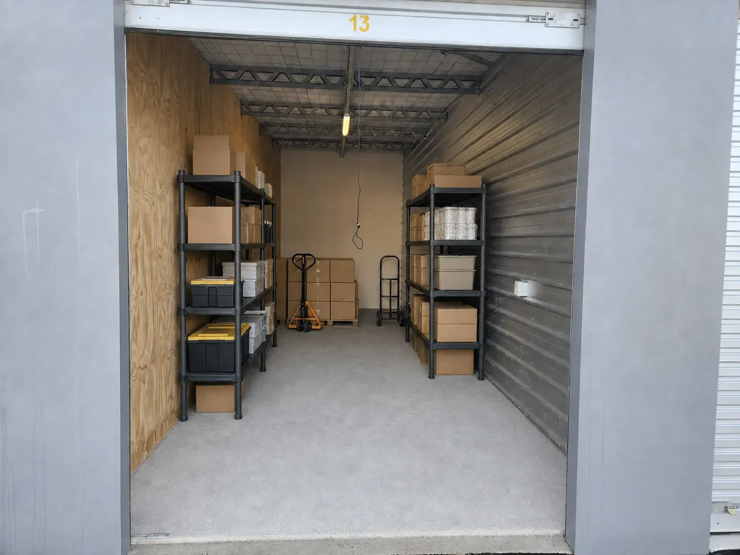 Commercial stock, packaged supplies and freestanding shelving inside a storage unit at Myt4you Storage Ravenswood