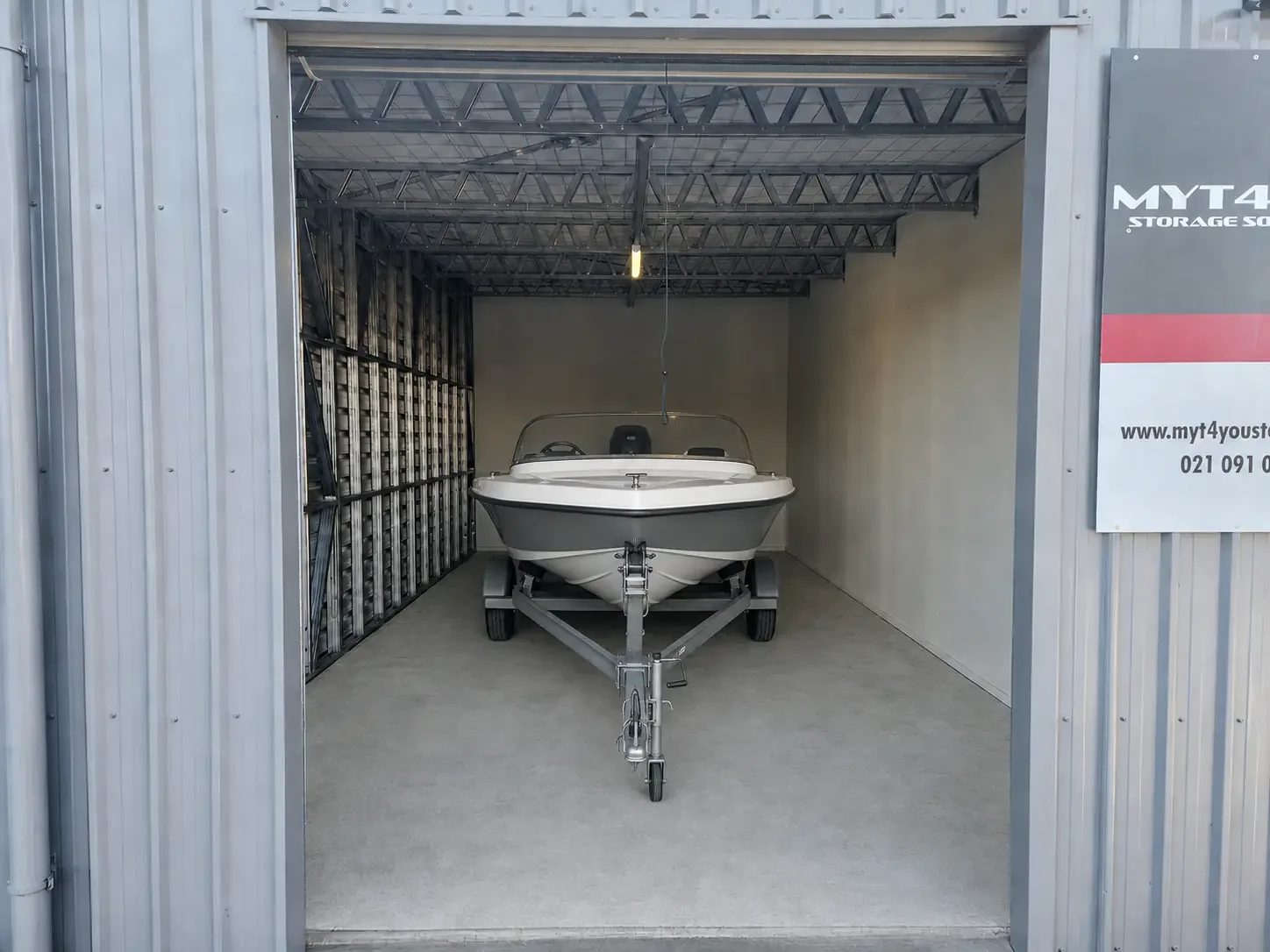 Compact aluminium boat and trailer inside an enclosed storage unit at Myt4you Storage Ravenswood