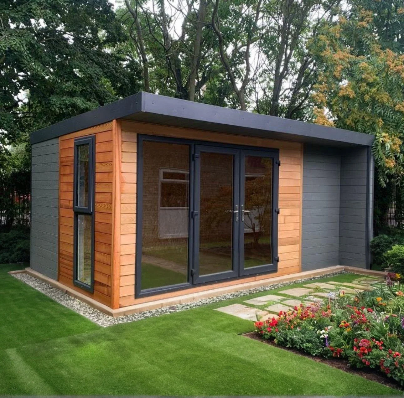 Garden room constructed using Structural Insulated Panels with bifold doors in a garden with lawn.