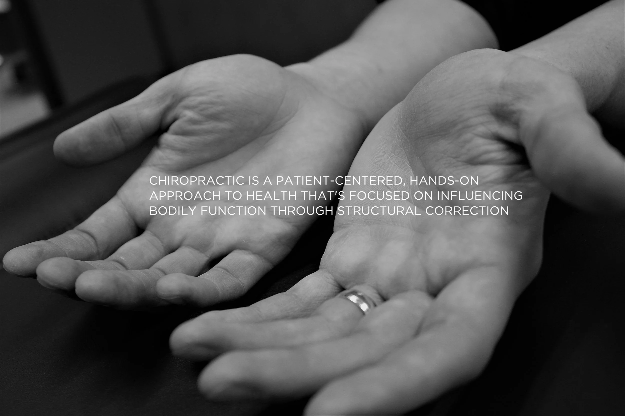 Close-up of hands with a ring, open with palms facing up, with text overlay about chiropractic care and structured health approach.