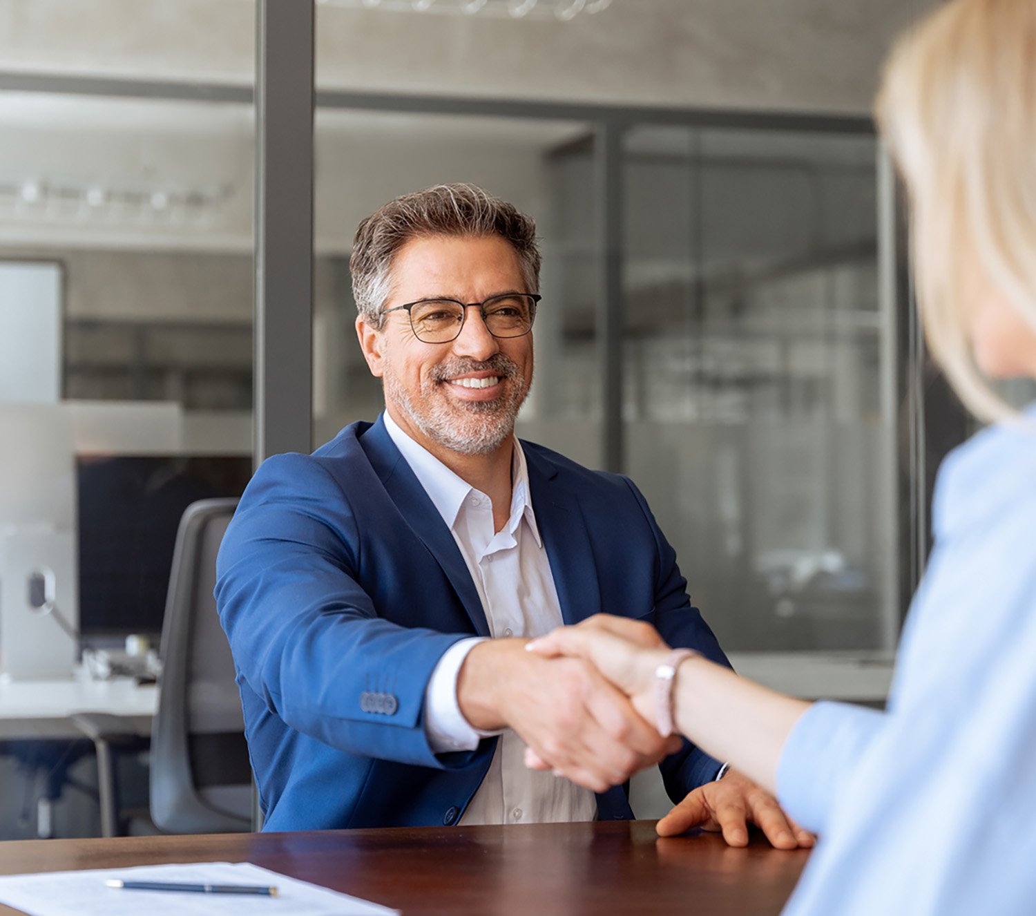 Happy mortgage loan officer shaking hands with customer