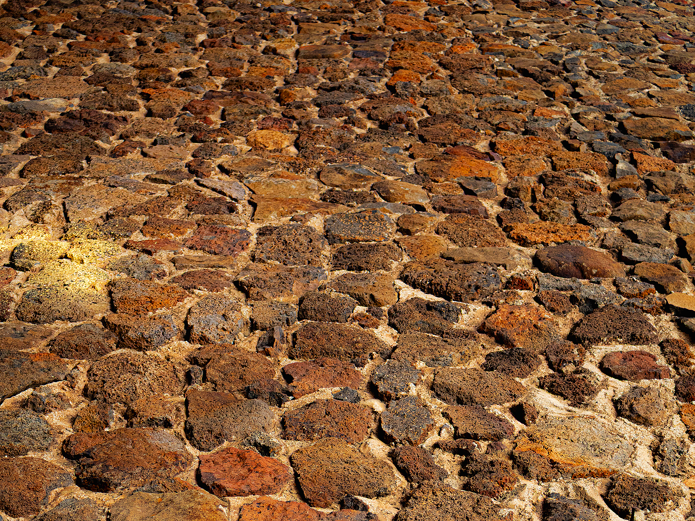 Close-up view of a large area of uneven, reddish-brown volcanic rock or lava stones.