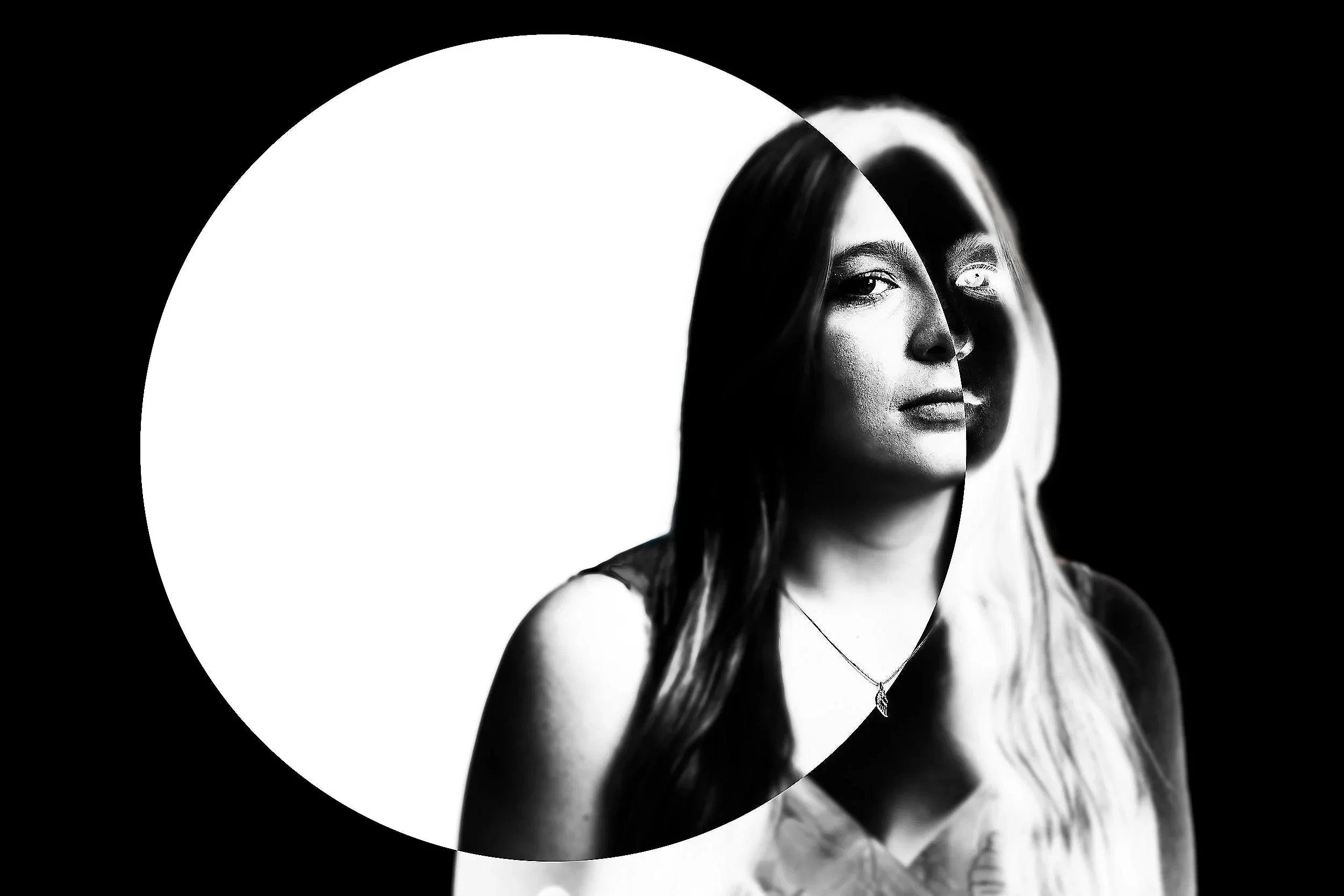 Black and white portrait of a woman with long hair, looking to the side, with a circular vignette effect.