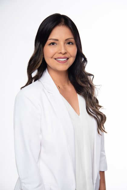 Portrait of a woman with long dark hair wearing a white professional blazer, smiling at the camera against a plain white background.