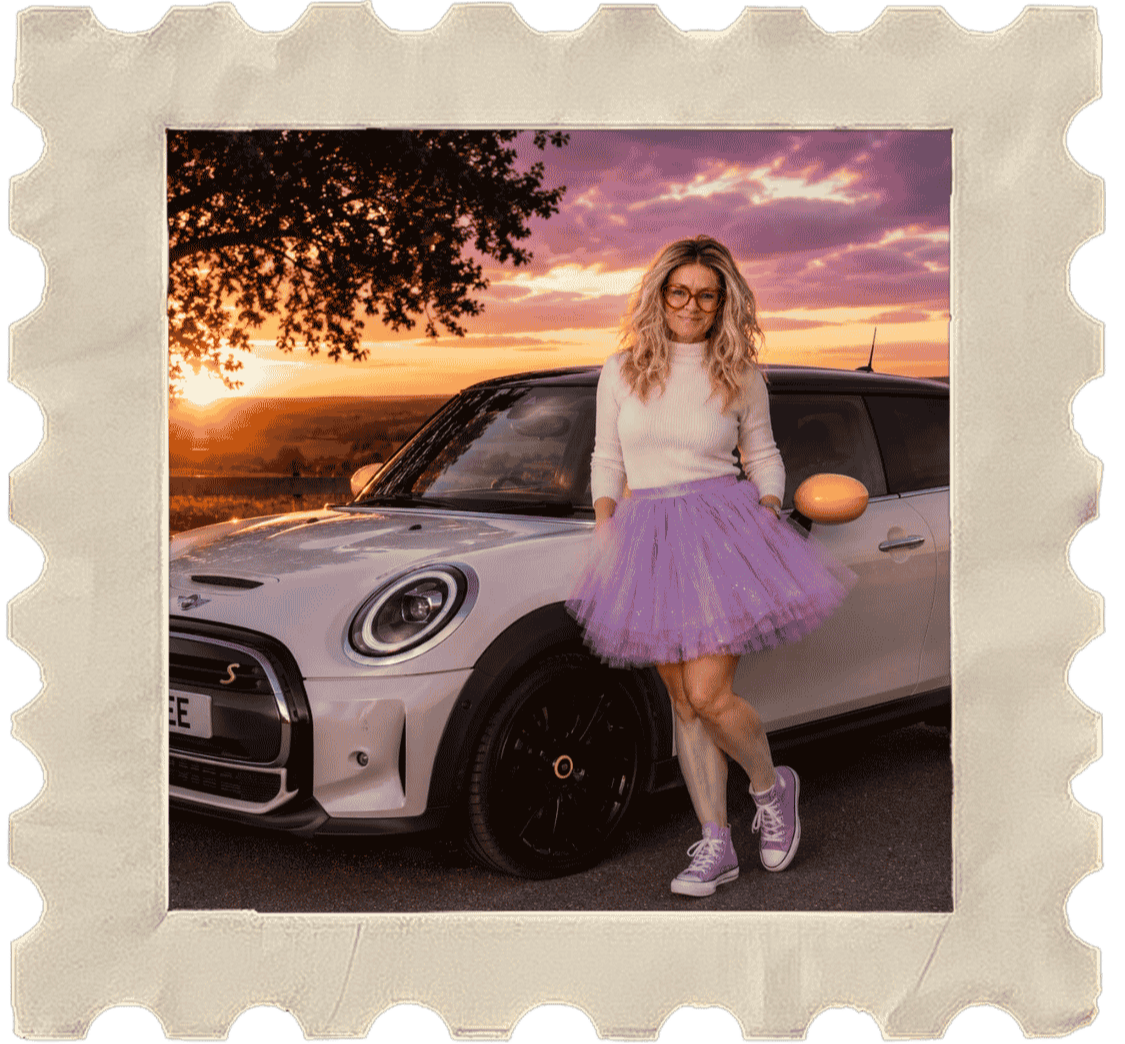 Helena from Helrica Massage Clinic standing beside her Mini Cooper at sunset, reflecting confidence, independence and self-expression.