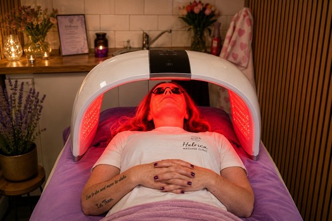 Client relaxing under LED light therapy during a beYOUtiful Facial at Helrica Massage Clinic in Littleport