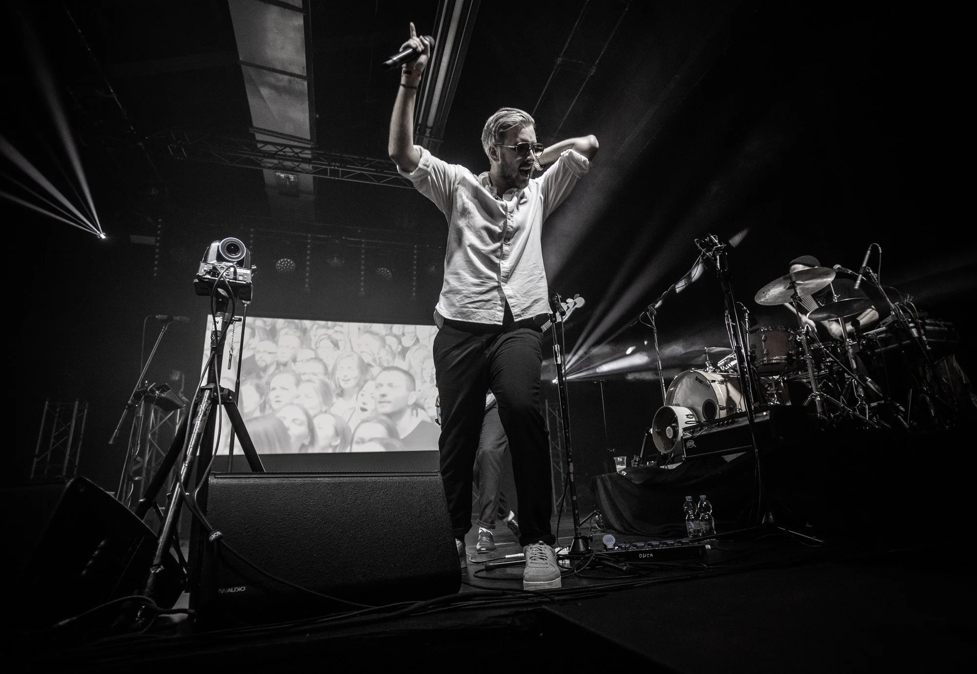 Eventfotografie bei einem Konzert: Sänger auf der Bühne mit Mikrofon, Licht und musikalischer Atmosphäre.