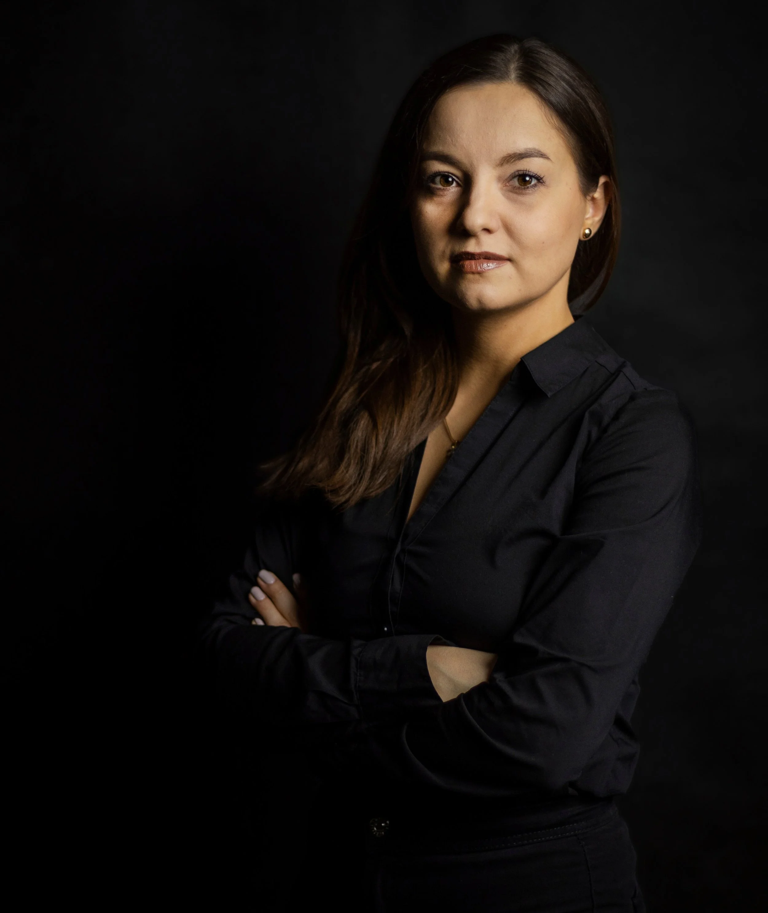 Professionelles Businessporträt einer Frau vor dunklem Hintergrund, aufgenommen in einem ruhigen und eleganten Studio-Look.