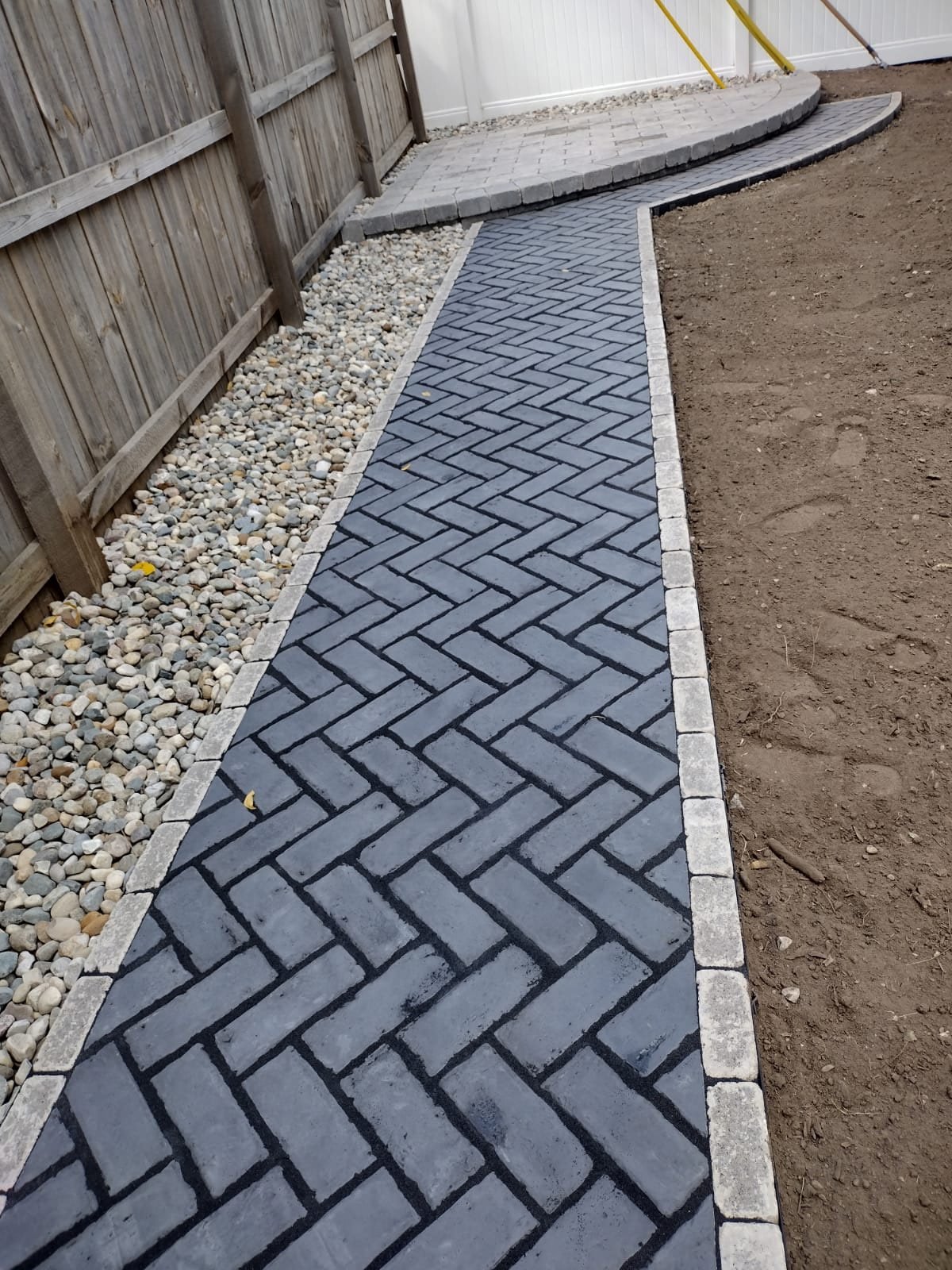 Satisfying result from another Synergy Lawnscape project the perfectly line dark brick goes well with the light rocks.
