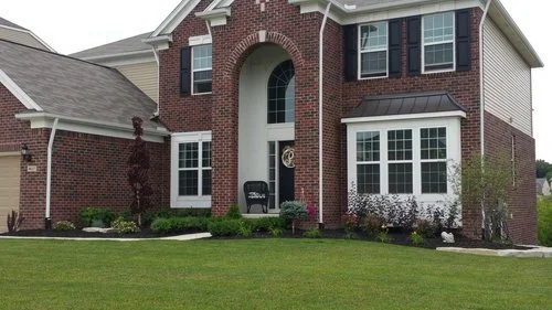 Residential lawn care and landscape maintenance featuring a clean front yard, trimmed beds, healthy grass, and improved curb appeal for homeowners.