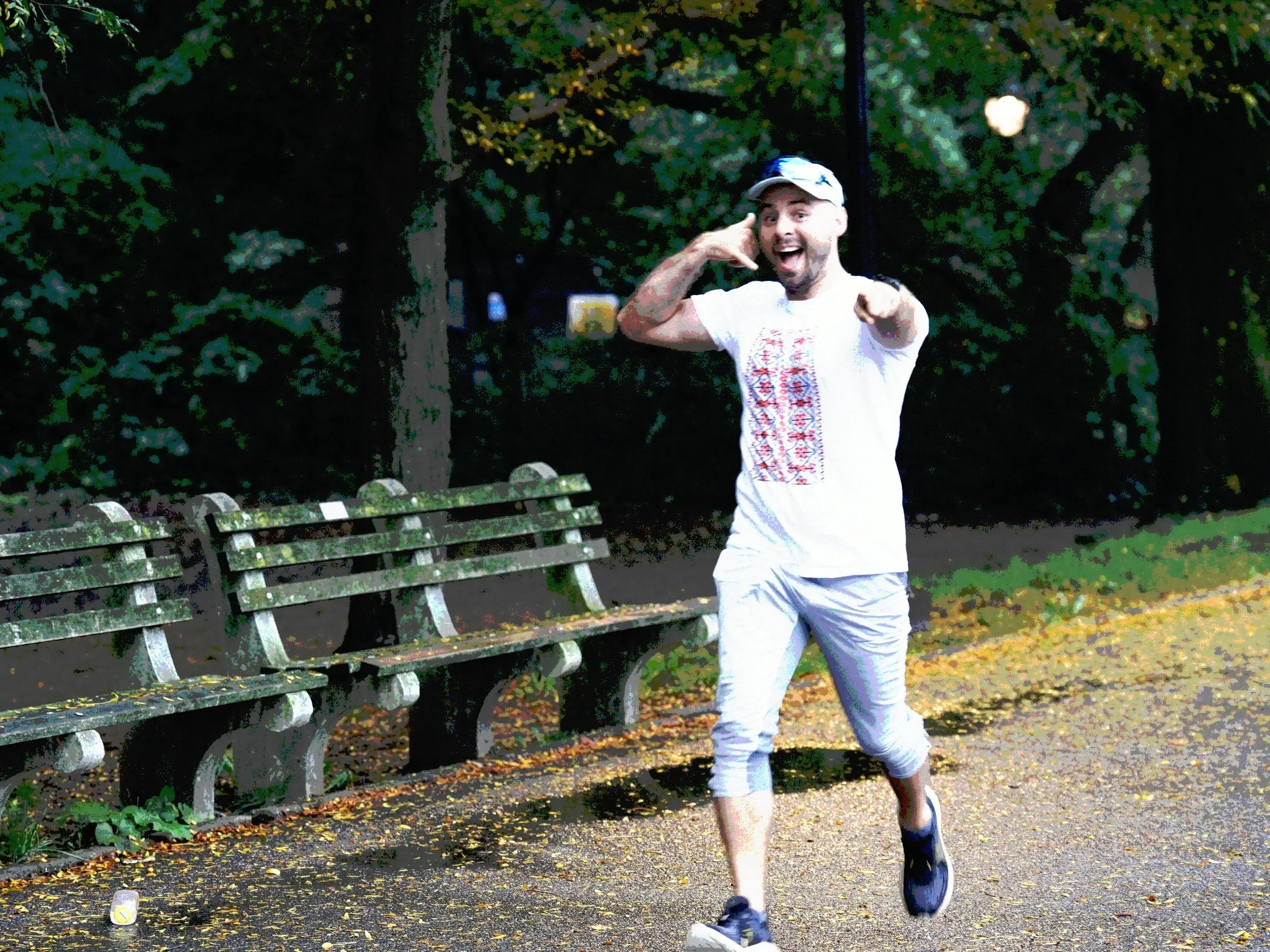 Man running in a park making a phone call gesture with his hand, inviting someone to call him