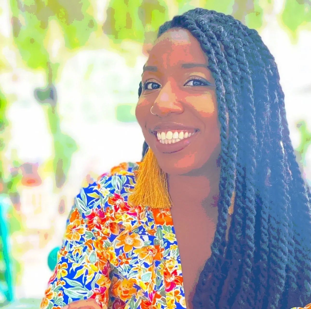 Founder of The South Design Research Studio, a Black woman with braided hair, smiling outdoors in a colorful floral top