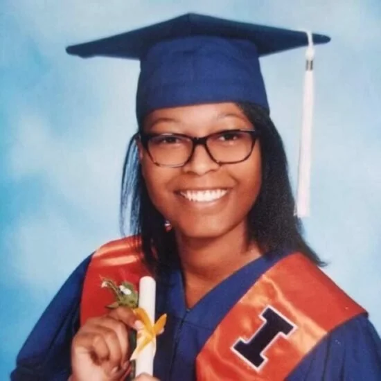 Young woman in graduation cap and gown holding a diploma.