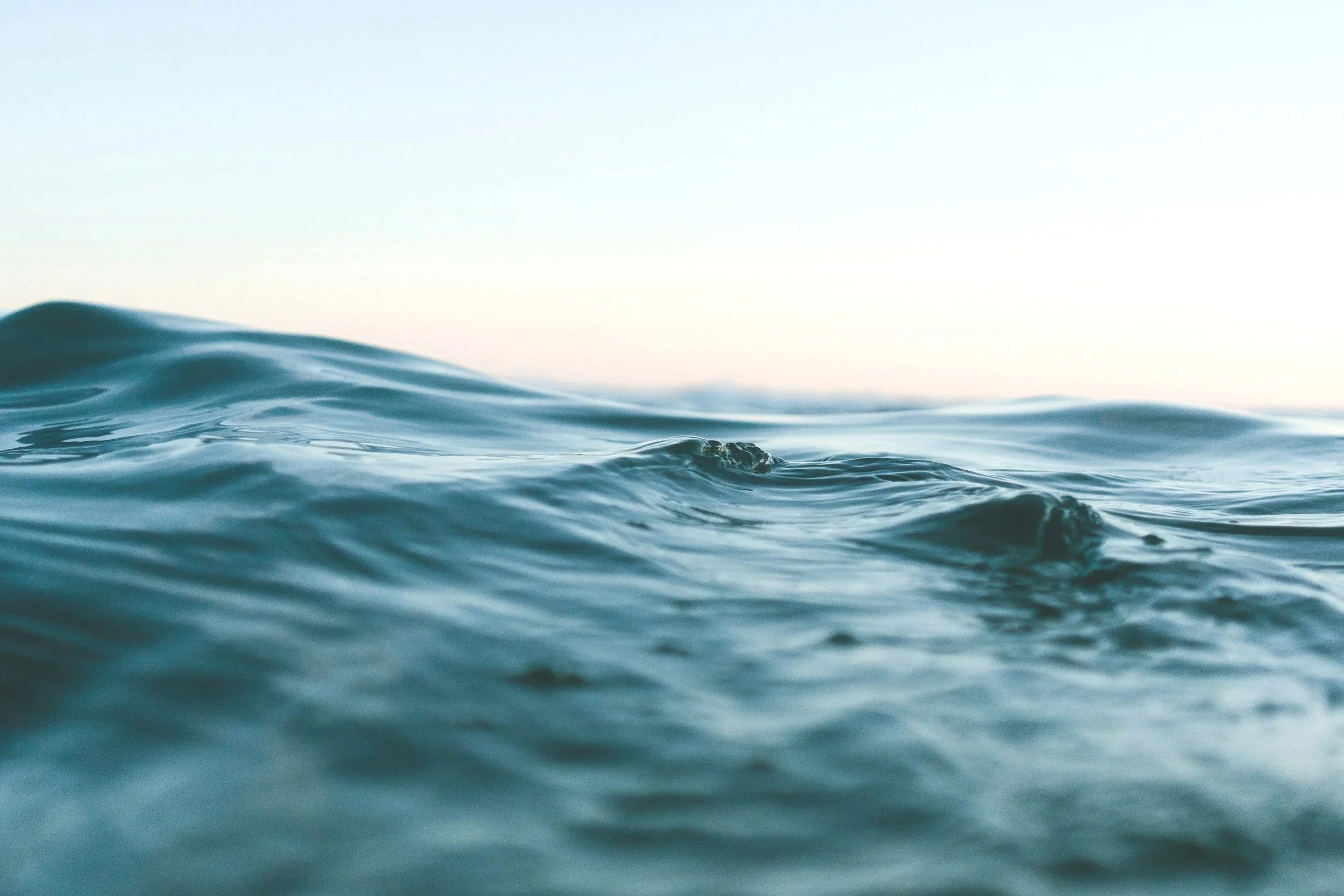 Close-up of ocean waves with a clear sky in the background during daytime.