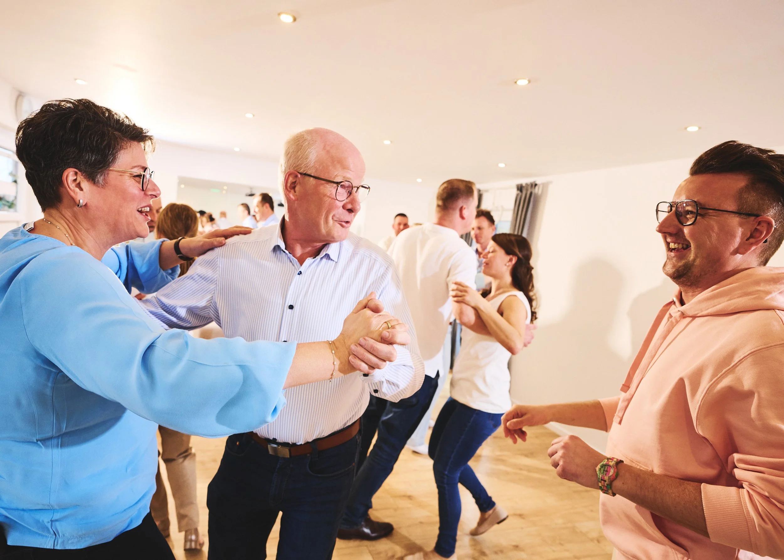 In der Tanzschule Winkler. Menschen, die in einer hell erleuchteten, modernen Raum tanzen, lachen und Spaß haben.